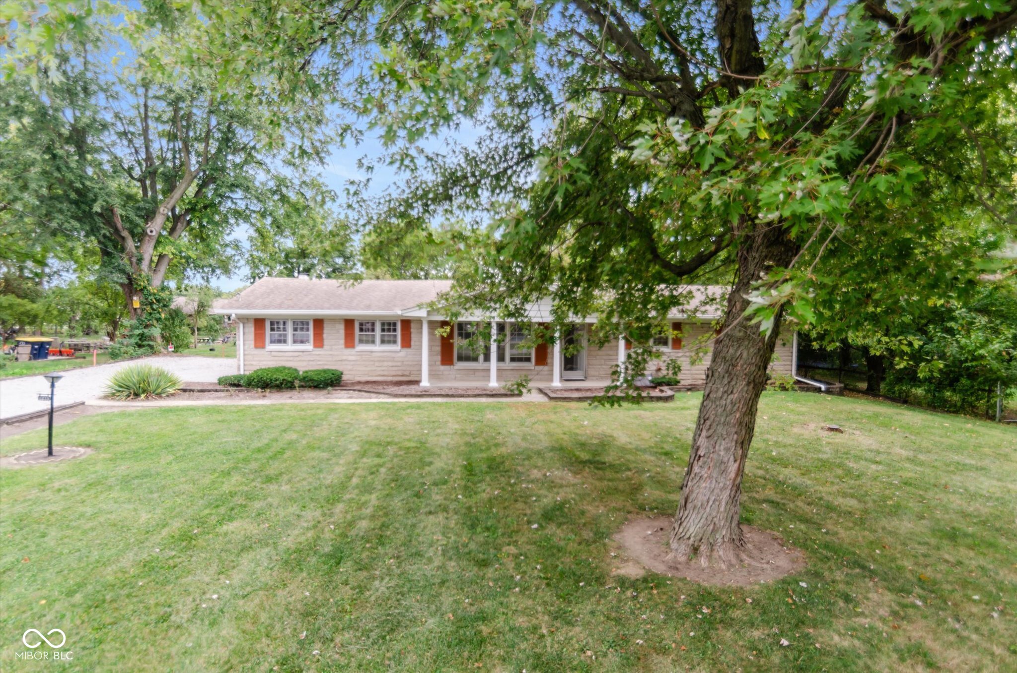 Discover the inviting home awaiting you at 2215 Albany ST, BEECHGROVE, IN. This single-family residence is ready to move in and start creating memories.  The Family Room serves as a warm and inviting space, anchored by a fireplace that promises cozy evenings and features a wood wall and built in bookshelves, adding character and charm. This home boasts a large living room as well for a quiet space of your own or an additional media room. The kitchen offers a functional layout with a kitchen peninsula, perfect for meal preparation or casual dining. The wood features in the kitchen and dining room, paired with multiple views of the backyard add rustic elegance and warmth, making these spaces both practical and aesthetically pleasing. Step into the sunroom, a tranquil retreat filled with natural light and a beautiful view of the backyard, ready for entertainment or your peaceful morning coffee. The home includes 3 bedrooms and 2 full bathrooms, one of which includes a convenient walk-in shower and additional door out to the sunporch. All 3 bedrooms have new vinyl wood flooring you will love for style and ease. Next make your way down to the basement which boasts tons of room to make this space your own, with plenty of light and enough space for hobbies, entertainment  and storage. This single-story home, built in 1962, sits on a generous lot of almost 1 acre,  offering ample space for all to enjoy. This warm, spacious home is a rare find and won't last long!