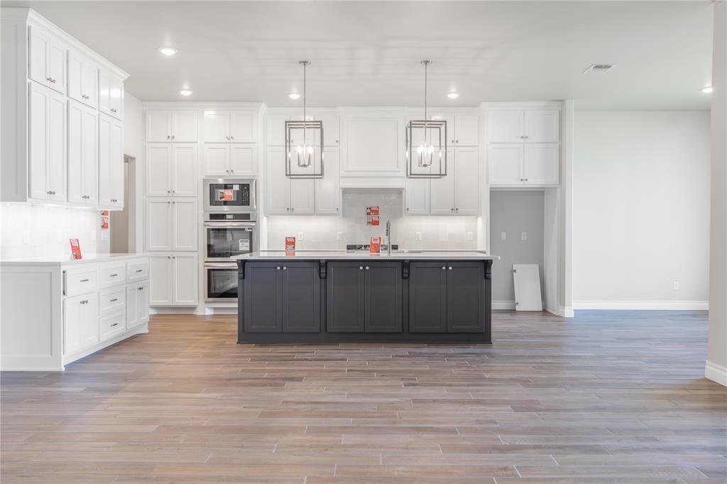 This Wesley Bonus Room floor plan includes 3,630 Sqft of total living space, which features 3,285 Sqft of indoor living space and 345 Sqft of outdoor living space. There is also a 590 Sqft, three car garage with an in-ground storm shelter installed. This desirable home offers 5 bedrooms, 3 full bathrooms, 2 covered patios, a large bonus room, a powder room, and a utility room. The great room supports an immaculate cathedral ceiling with a ceiling fan, a luxurious 3-panel sliding door with a 4' back patio extension, wood-look tile, rocker switches throughout, Cat6 wiring, and a gas fireplace surrounded by our exquisite stacked stone detail and built-in lower cabinets on both sides. The upscale kitchen boasts stunning pendant lighting, stainless steel appliances, including double ovens and a 5-burner cooktop, 3 CM countertops, vogue tile backsplash, well-crafted cabinets to the ceiling with cabinet hardware installed throughout and under cabinet lighting, a separate walk-in pantry, and a large center island that holds a roomy farm sink, a dishwasher, and a trash can pullout. The primary suite provides a sloped ceiling detail with a ceiling fan, a plush carpet finish, Cat6 wiring, and windows. Attached is the main bath which has a batwinged vanity with framed mirrors, 3 CM countertops a large European walk-in shower, a private water closet, a free-standing tub, and a HUGE walk-in closet! The covered outdoor living area welcomes a wood-burning fireplace, a gas line for your grill, and a handy TV hookup. Other included features for this elegant home include our healthy home technology, an air filtration system, a tankless water heater, double glazed vinyl low E windows with argon, R-44 and R-15 insulation, a fresh air ventilation system, and so much more!