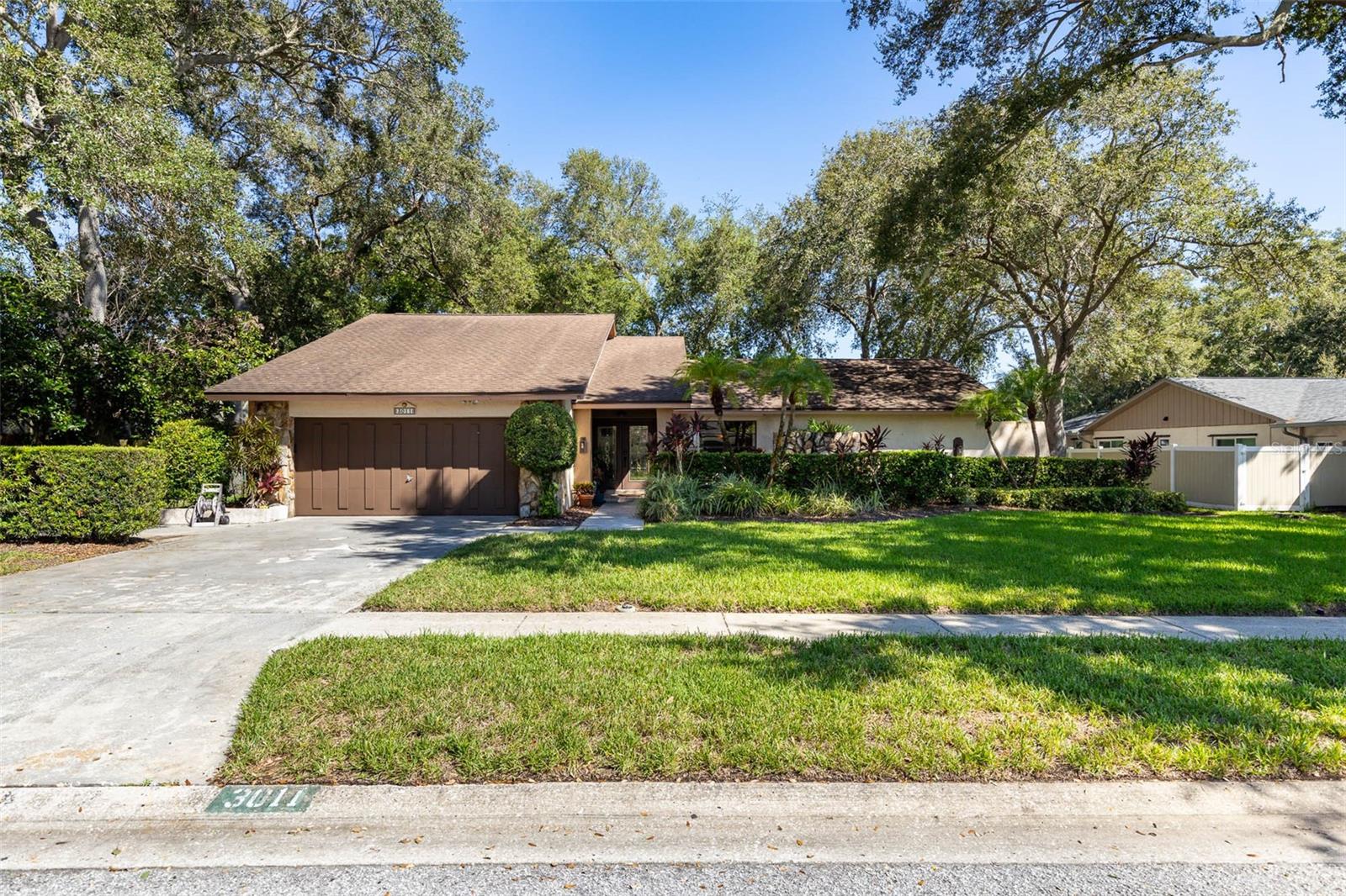 WELCOME TO ENISWOOD and an opportunity to make a well-designed Palm Harbor pool home your own! This 3 bedroom, 2 bath home offers 2,068 square feet of living space on a generous .30-acre lot with a desirable split-bedroom floor plan and plenty of room to update and personalize over time. The spacious GREAT ROOM features vaulted ceilings with exposed beams, a wood-burning fireplace and wet bar, while the adjoining kitchen offers abundant cabinetry, granite countertops, breakfast bar and separate dinette. A formal dining room provides additional entertaining space, and the primary suite is privately positioned with a walk-in closet and en-suite bath. One of the standout features of the floor plan is the connection to the outdoor living space, with MULTIPLE ACCESS POINTS from the home to the expansive covered lanai and SCREENED POOL area, making it easy to move between indoors and out whether entertaining, relaxing by the pool or simply enjoying Florida living. Mature landscaping and a nicely sized backyard add to the setting. While the home offers a strong floor plan and plenty of potential, buyers should anticipate updates including flooring and pool finish sooner than later. Several major components have already seen more recent attention, including the ROOF in 2016, WATER HEATER in 2018, HVAC in 2023, and ELECTRICAL PANEL updated in 2025. Located in ENISWOOD, one of Palm Harbor’s most sought-after established neighborhoods, known for its tree-lined streets, mature landscaping, larger homesites and distinctive homes. Tucked alongside neighboring Autumn Woods, Eniswood offers the kind of established residential setting that has long made this pocket of Palm Harbor especially desirable. Beyond the neighborhood, you are close to the PINELLAS TRAIL, area parks and waterfront recreation, golf, Gulf beaches and the restaurants, breweries, shops and local events of DOWNTOWN PALM HARBOR. Add Palm Harbor Middle and Palm Harbor University High zoning, and this is an opportunity to create exactly what you want in a neighborhood and location buyers continue to seek out.