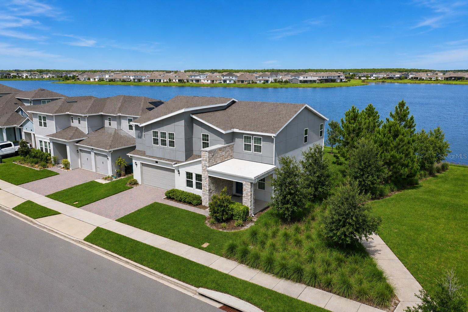 This stunning lake-view home offers the perfect blend of modern design, premium upgrades, and an unbeatable Lake Nona location—home to highly rated schools and some of the most sought-after neighborhoods in Central Florida. Situated on a corner lot along a private street, this 4-bedroom, 4-bath residence delivers exceptional privacy, picturesque water views, and the added benefit of a green-space park directly next to the home, providing open views and a peaceful natural setting.Inside, the home features luxury vinyl plank and tile flooring throughout, eliminating carpet and enhancing durability and style. The highly desirable open floor plan creates a bright, airy environment with seamless flow between the kitchen, dining, and great room—ideal for both entertaining and everyday comfort.The home is also equipped with surround-sound systems on both floors and outdoors, offering an elevated audio experience whether hosting guests or enjoying a quiet evening at home.Additional highlights include an oversized garage storage area, perfect for tools, sports equipment, bikes, or seasonal items—providing functionality rarely found in similar homes.Upstairs, a spacious bonus room provides endless possibilities for additional living space. Every detail has been thoughtfully upgraded and meticulously maintained, delivering the appeal of new construction with added value already in place.A rare opportunity to own a move-in-ready, lake-view home that combines space, style, technology, and flexibility in one exceptional package—right in the heart of Lake Nona.