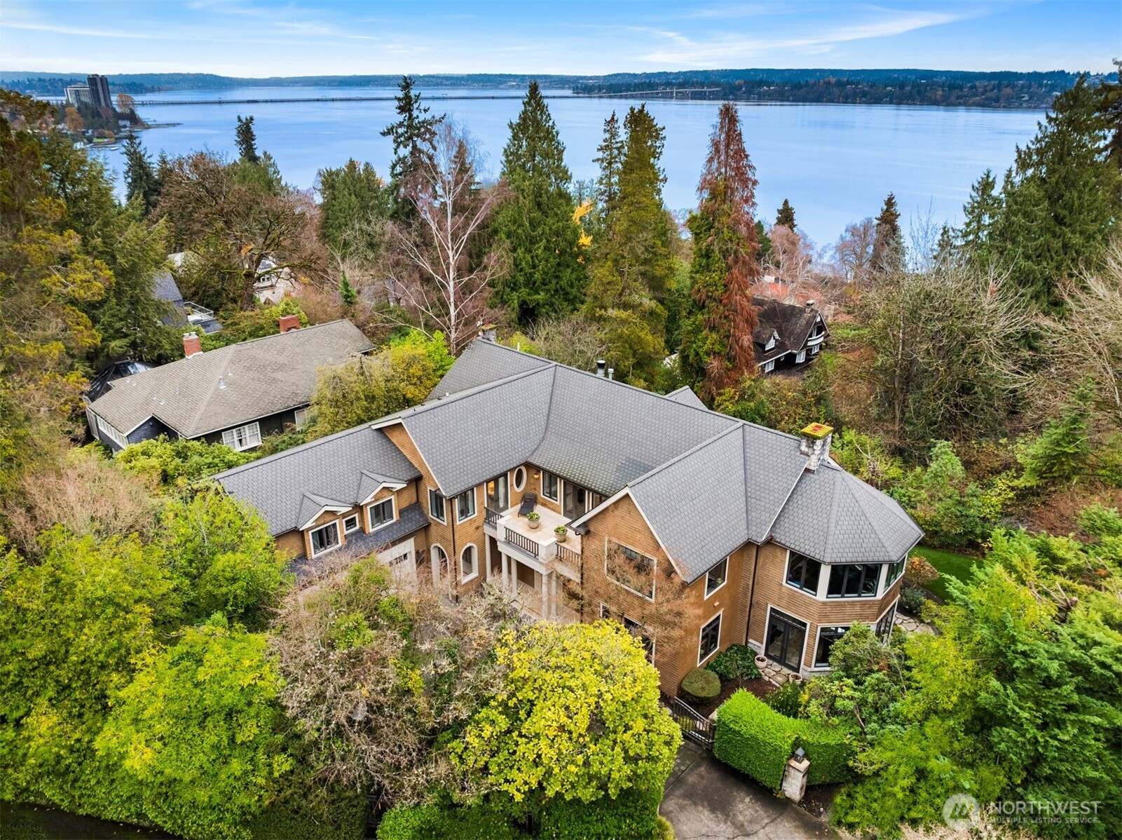 A rare gated estate on a private double lot in Denny Blaine, offering sweeping views of Lake Washington, the Cascades, and the Bellevue skyline.  Set on approximately .37 acres with level, usable grounds, the property offers an uncommon combination of privacy, scale, and livability in one of Seattle’s most sought-after neighborhoods.  Designed for both everyday living and entertaining, the home features expansive gathering spaces, seamless indoor-outdoor flow, and multiple vantage points to take in the view.  A recently remodeled gourmet kitchen anchors the main level, opening to inviting living and dining spaces filled with natural light.  The upper level is highlighted by an exquisite primary suite with its own office, spa-inspired bath with steam shower, home gym, and serene outlooks.  The fully finished lower level provides exceptional flexibility, including a temperature-controlled wine room, generous recreation and bonus spaces, and guest accommodations with separate exterior access.  Thoughtfully designed for modern living, the home also includes laundry on both upper and lower levels.  Private, gated, and set on a rare double lot. This is a unique opportunity to own a truly livable estate in Denny Blaine.