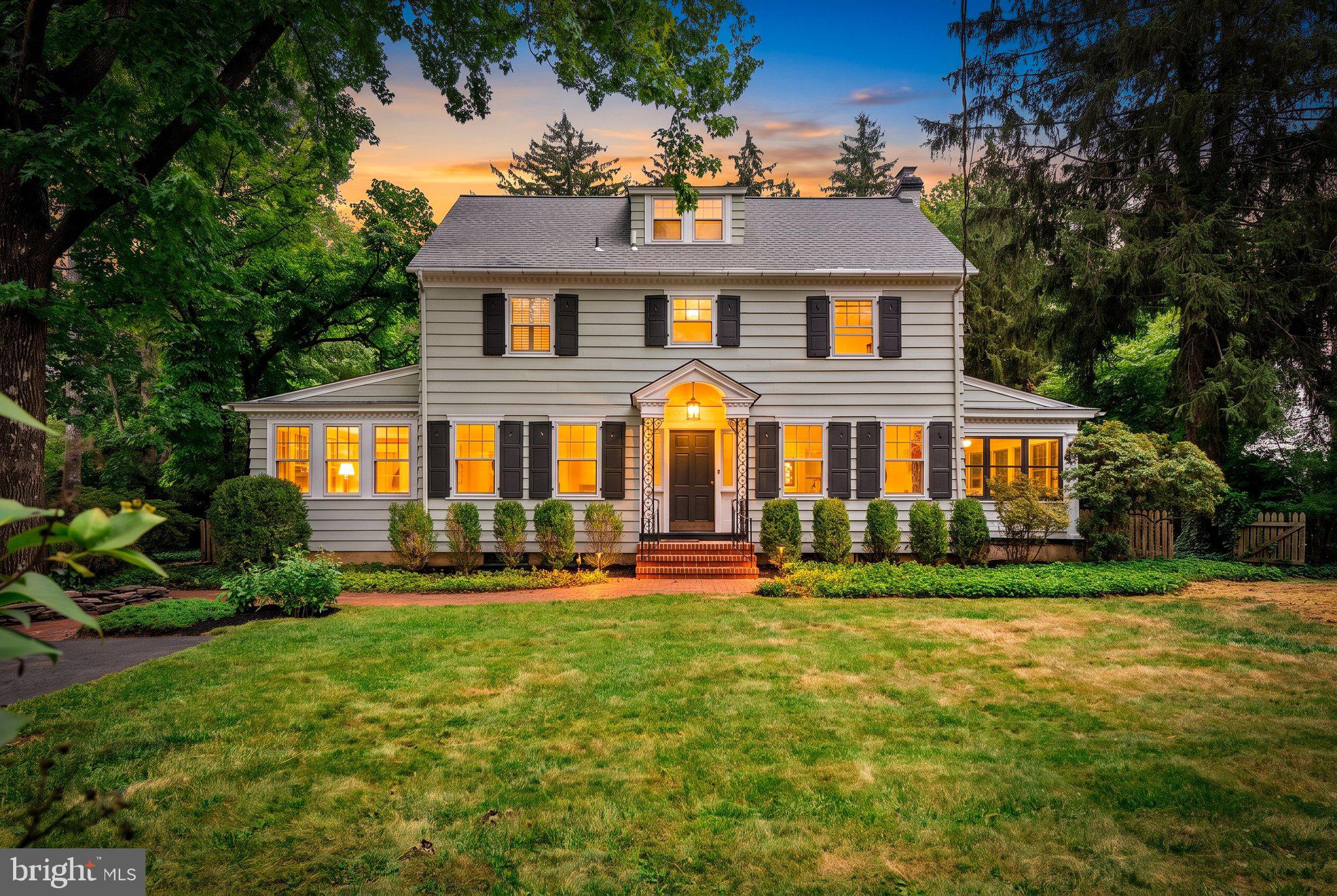 Set in Princeton's sought-after Riverside neighborhood, this 1922 center-hall Colonial pairs timeless architectural character with meaningful recent updates, including a new roof, a 6-year-old furnace, and freshly painted interior and exterior — a truly move-in ready opportunity. Inside, original details endure: rich hardwood floors, generously proportioned doorways trimmed in layered millwork, and softly curved wall-to-ceiling transitions that speak to the home's 1920s craftsmanship. The main level flows easily from a bright living room with fireplace, to a formal dining room, a comfortable family room, and an eat-in kitchen outfitted with granite counters, glass-front cabinetry, and high-end stainless appliances. Upstairs, a private primary suite private primary suite with new in-suite master bathroom is joined by two additional bedrooms and a shared full bath, while the finished attic level adds a fourth en suite bedroom along with a flexible bonus room perfect for a home office or studio. Outside, mature pines frame the property and shade sweeping beds of ivy and rhododendron, a dramatic weeping cherry tree flowers each spring,  the raised deck — an ideal setting for outdoor entertaining. All of this just minutes from downtown Princeton and Princeton University, with easy access to acclaimed restaurants, theater, live music, and everyday conveniences.