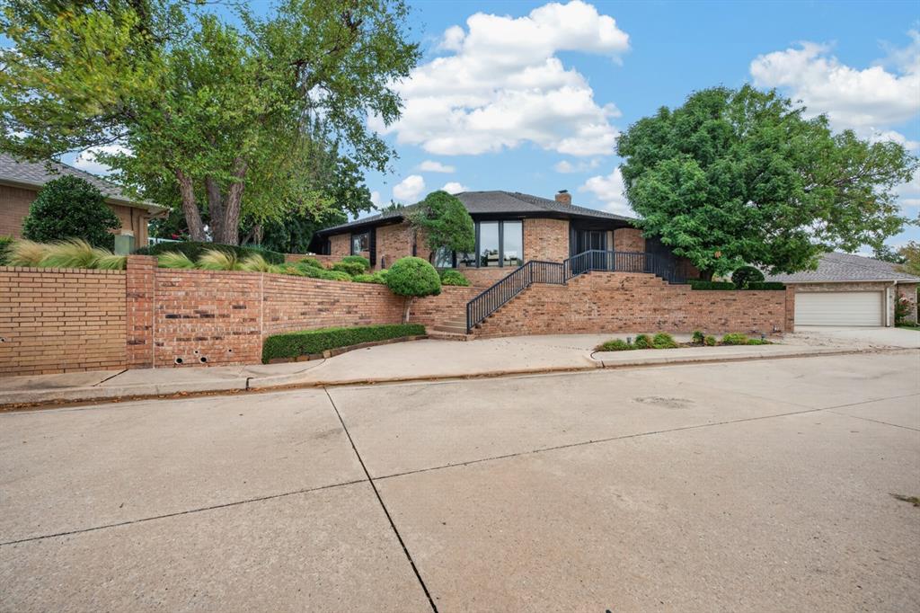Welcome to 545 E Oak Pl, tucked away behind a second set of gates within Edmond’s prestigious Oak Tree community. This beautifully updated 2-bedroom, 2-bathroom patio home with a dedicated study offers a unique combination of privacy, character, and spacious living. Step inside to discover refreshed interiors, beautiful wood flooring, and an abundance of natural light pouring through expansive windows. The home's distinctive U-shaped design creates a seamless connection between the indoor living spaces and multiple private outdoor patios. The expansive living room features a striking fireplace and flows effortlessly into the kitchen and dining areas, making it ideal for entertaining. The spacious kitchen offers abundant cabinetry, a large center island, generous counter space, and a breakfast area overlooking the outdoor living spaces. A separate formal dining room provides additional room for hosting family and friends. The private primary suite features a beautifully updated bathroom with a freestanding soaking tub, separate shower, dual vanities, and an impressive walk-in closet with custom built-in storage. The second bedroom offers its own private bathroom, while the dedicated study features rich wood paneling and built-in bookshelves, creating an inviting workspace or additional sitting area. A generously sized utility room provides extensive cabinetry and storage. Outside, enjoy multiple private patios surrounded by mature trees and established landscaping, offering peaceful spaces to relax or entertain. Experience the privacy, character, and convenience of patio home living in one of Edmond's most desirable gated communities, with Oak Tree Country Club amenities available through separate membership.
