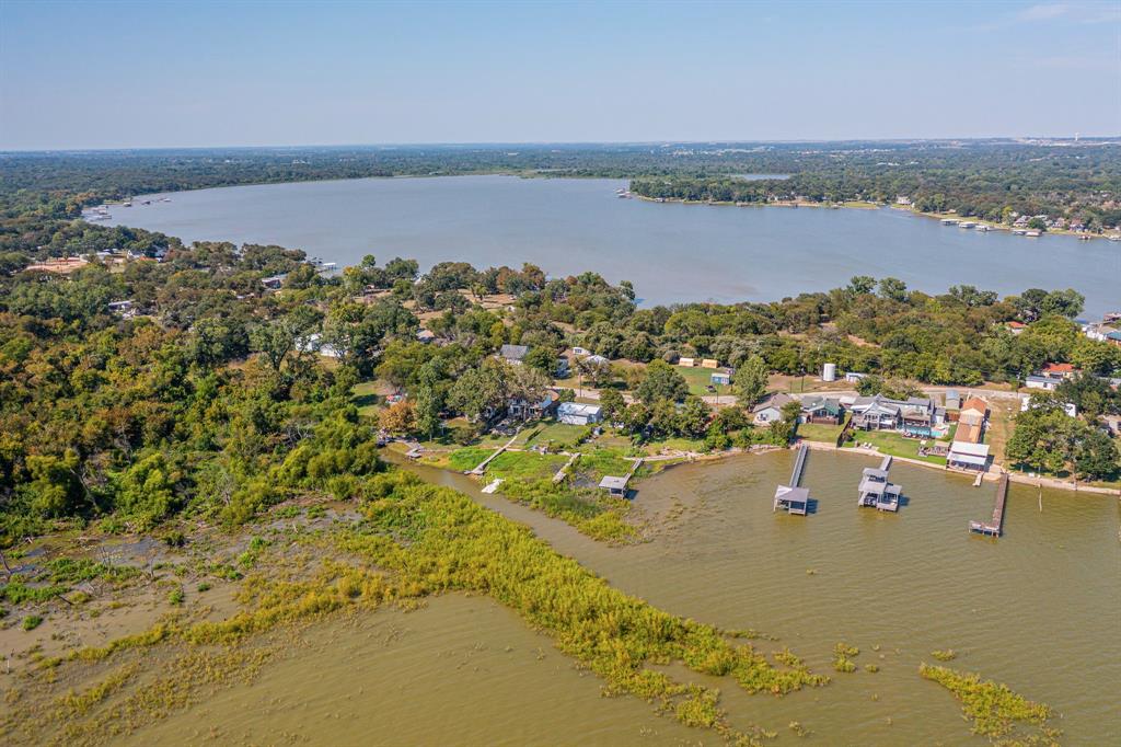 Ideally located just minutes from TX-199 in Azle, TX, this beautifully updated home offers direct access to Eagle Mountain Lake with a private dock—perfect for boating, fishing, or simply enjoying the water. The fenced backyard features a covered upper porch that connects to the secondary bedrooms and includes stair access to a lower-level uncovered patio, creating multiple outdoor spaces to relax or entertain. The front of the home includes a one-car carport for convenient parking.

Inside, the home features a modern, open-concept layout with a fully updated kitchen complete with a center island, breakfast bar, and a spacious utility room that doubles as a pantry with added shelving. The kitchen flows directly into the dining and living areas, where recessed lighting and large windows create a bright, inviting space. The primary suite is located on the main level and includes an upgraded vanity, walk-in shower, and walk-in closet, along with a half bath for guests. Upstairs, two generously sized secondary bedrooms each have their own full bathrooms—one of which is oversized and ideal for use as a flex room, guest suite, or multipurpose area.

This home offers the best of lake living with nearby amenities such as public boat ramps, scenic parks like Shady Grove Park with its lakefront beach, fishing pier, playground, walking trails, and more—all just a short drive from shopping, dining, and everyday conveniences. With no HOA, you’ll enjoy the freedom to make this property truly your own.

Discounted rate options and no lender fee future refinancing may be available for qualified buyers of this home.
