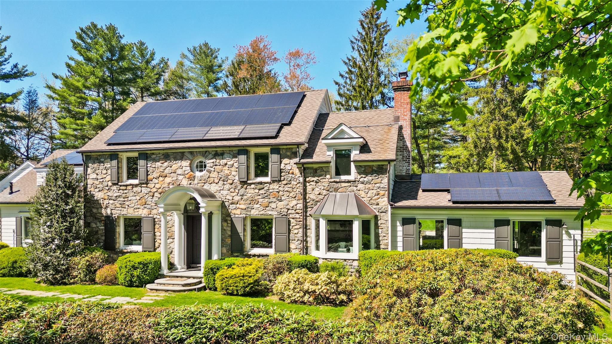 Welcome to this timeless and stunning Colonial, sited on 1.3 beautifully landscaped, private acres. This gracious 4-Bedroom Colonial blends classic architectural details with modern amenities -- open renovated kitchen with large island w/seating, spa-like bathrooms, new windows, solar paneling, Sonos throughout, a 2-bedroom cottage over the garage for long term guests, and a stunning Shoreline pool with new pool filter and heater. Hardwood floors, walls of new windows, stunning millwork create a warm and inviting setting -- and the renovated chef's Kitchen is a showstopper. The main floor features formal and informal gathering areas with wood-burning or gas fireplaces, a newly renovated eat-in Kitchen, spacious Mudroom with Laundry area and storage, Den/Sitting area with access to the pool + back yard, a delightfully bright Home Office with custom built-in cabinetry, a wonderful Great Room with wood burning fireplace that accesses the pool and back yard and a generous-sized Dining Room with wood-burning fireplace for friends to gather. Upstairs, the Primary Suite has a newly renovated spa-like Bathroom with two vanities, steam shower and soaking tub. Three additional bedrooms and two renovated Baths complete the upstairs. Above the two-car garage (with electric car charger) is another living space -- including 2-bedrooms, sitting area, Kitchenette and a screened-in porch. The property is sublime. Flat, manicured lawns, landscaped flowering trees + shrubs and a beautiful outdoor patio all center around the Shoreline pool. A true focal point for this incredible home.