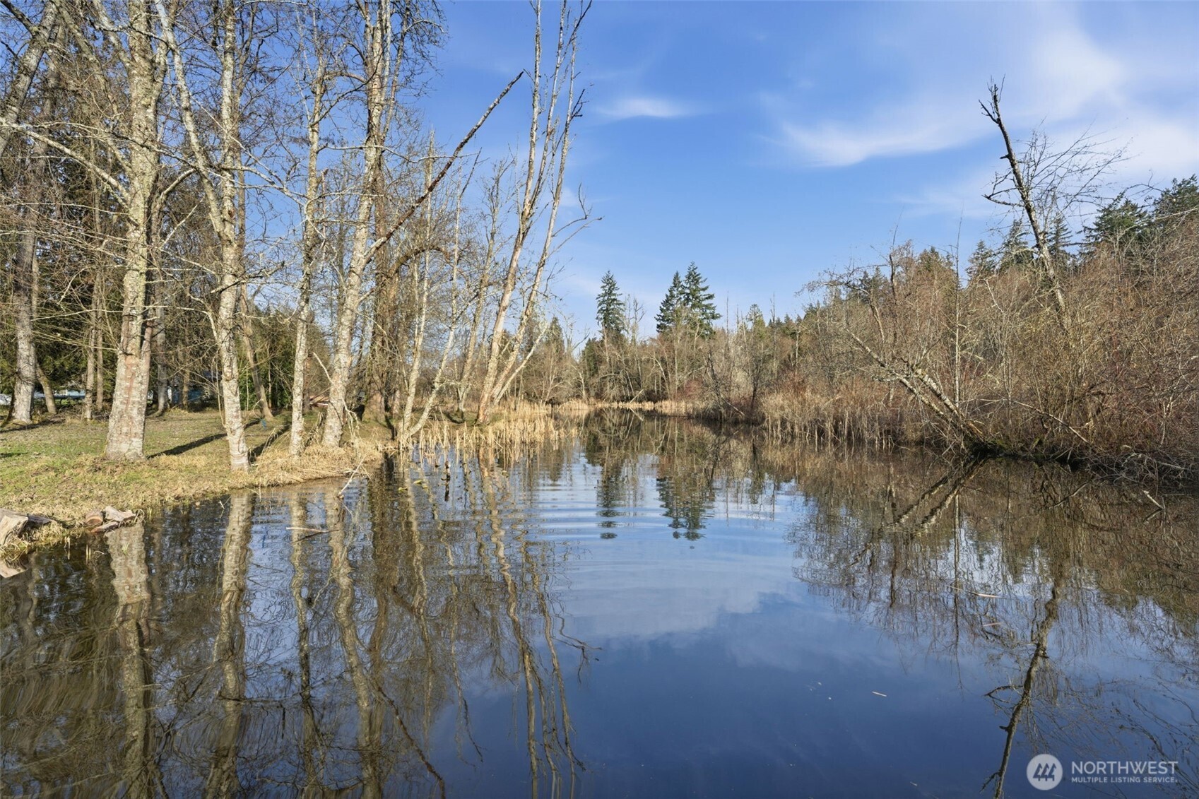 This serene property spans 2 parcels w/ septic, water, electricity & a pump house that includes washer/dryer, utility sink, and toilet. Embrace the easy life on 130’ of Lake Tanwax Creek frontage with canal access to the lake! Enjoy peaceful mornings fishing or watching waterfowl from your new 25’ dock, then head out from your private boat launch for year-round recreation. Cottage ready for remodel or rebuild. Pierce County approved plans for a home, and septic. Current biology & geological reports and site plan included. Cleared RV pad with hookups. Private driveway, no HOA. Public boat launch, resort store, and camping nearby. Endless options: retreat, compound, full time living or an investment! Additional lot next to this is listed and also available for sale! Please do not walk property without your real estate agent!