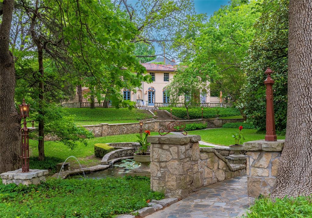 6840 Lakewood is a jewel, a timeless estate in the most beautiful setting on the boulevard.  With its architecturally significant home situated on a .442 acre, hillside lot, complete with a pond, it’s hard to imagine a more idyllic landscape.  Designed by Bertram Hill, the current owner has been a marvelous steward of the property. During their tenure, they have expanded the home to include a guest suite; a larger kitchen; a two-story, secondary living area; and an expanded primary bedroom suite.  Across the front is the stately living room with a hammered metal fireplace.  French doors in every room on the 1st floor open onto terraces, lawns, and walled courtyards.  Dine alfresco in the spring and enjoy the spectacular view from the home’s wide front terrace or enjoy a holiday meal in the home’s frescoed dining room.  There is a Rookwood tile floored entry foyer-solarium; two opera worthy staircases; leaded glass windows; and European inspired brass hardware.  A multi-hued Ludowici tile roof and masonry construction marked by a subtle, crescent finish are among many considered details.  The large European style kitchen is anchored by a French made LaCanche range and oven, and the central island, with its exuberant terrazzo-finishes is perfectly sized for cooking and dining.  There are 4 bedrooms.  The primary suite has been expanded to include an exquisite, mosaic-tiled bath cabinetry detail and natural light.  The home’s second bedroom is as inviting as the primary suite and shares a significant bath with vintage-style and black & white appointments with a fourth bedroom.  There are many beautiful and well loved homes in Lakewood, however, no home on Lakewood Blvd has the matchless combination of setting and architectural design found here.