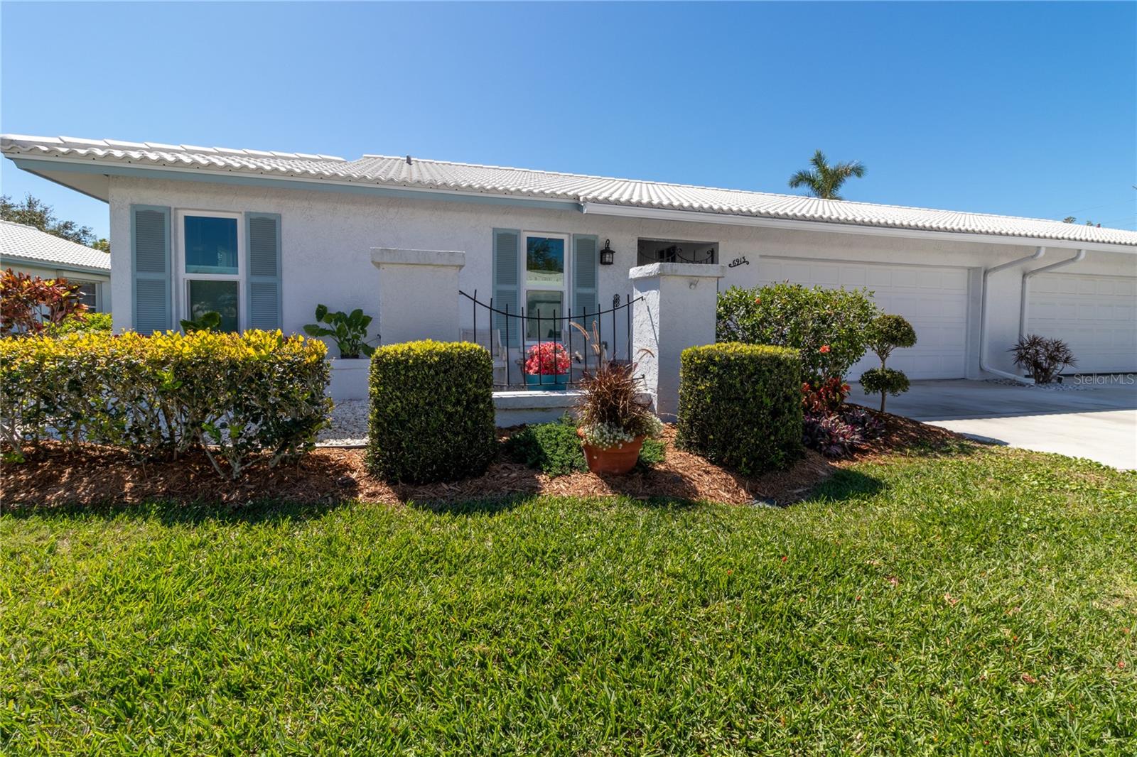 One or more photo(s) has been virtually staged. Welcome to your dream 55+ community in charming West Bradenton! This beautifully maintained condo, nestled on a quiet cul-de-sac in the sought-after Village Green community, offers the perfect blend of comfort, convenience, and peace of mind. Built in one of the most desirable high-and-safe locations. Securely located in Flood Zone X and Evacuation Zone E.  With over 1900 sq. ft. of versatile living space, this home features 2 spacious bedrooms, 2 updated bathrooms, and a large galley-style kitchen with new quartz countertops, striking herringbone backsplash, and classic mid-century modern cabinetry.  Expansive living areas include bright living/dining room, cozy family room, and a sun-filled Florida room.  A roomy 2-car garage with built-in cabinets and shelving, perfect for storage or workspace. Recent updates make this home truly move-in ready with luxury vinyl flooring, nearly all-new windows, refreshed bathrooms, and exterior upgrades including new driveway and charming paver walkway and patio.  Step outside and you’re moments from the sparkling community pool, perfect for relaxing or socializing. The location can’t be beat – minutes from Anna Maria Island’s beaches, excellent medical facilities, shopping, dining, and outdoor escapes like Robinson Preserve, Palma Sola Botanical Park, and DeSoto Park.  This home is ideal for both relaxation and entertaining, offering a lifestyle that’s as practical as it is enjoyable. Don’t just dream about Florida living—make it your reality!