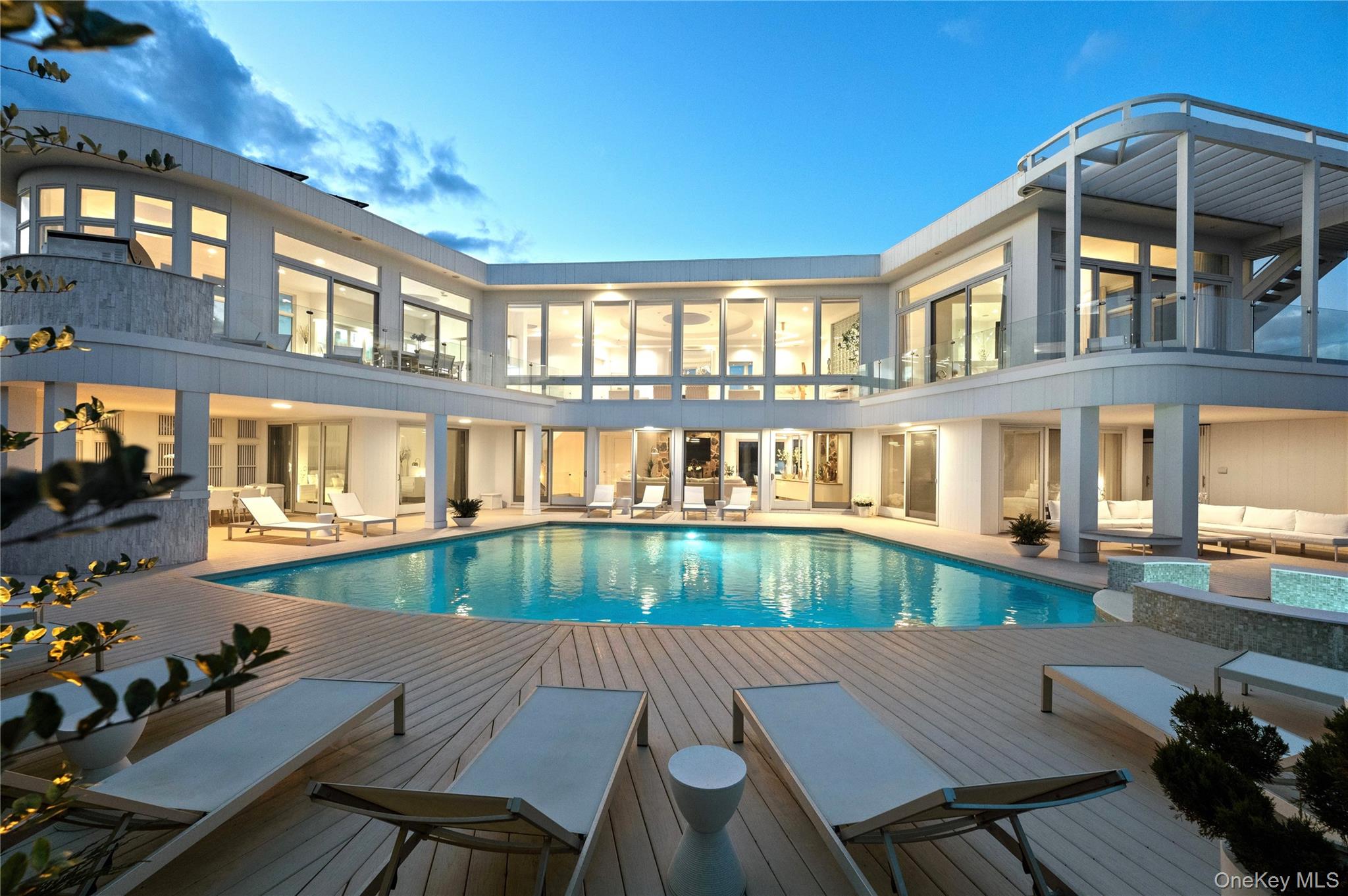 OCEANFRONT MANSION MASTERPIECE
YOUR 5-STAR OCEAN RESORT PARADISE AWAITS!!! Simply beyond compare, it will be love at first sight with this awe-inspiring 8,000 SF custom oceanfront mansion retreat on two magnificent acres with 200 feet of private oceanfront. An artistic masterpiece of modern architecture, combined with a world-class private beach, breathtaking ocean views, and cool Atlantic breezes provides the ultimate setting for luxurious living, relaxation, inspiration, and unmatched privacy.

Located off an exclusive private cul-de-sac lane, down a 400 foot-secluded drive, you are greeted with a contemporary masterwork of three extraordinary stories. majestically facing the Big Blue. You will be dazzled by the soaring 11 foot ceilings and floor-to-ceiling walls of glass throughout, affording amazing ocean panoramas. Surrounding the home is gorgeous landscaping with lush gardens, shrubbery and privacy trees creating a Zen setting. Not to mention over 4,000 square feet of spectacular new decking and exquisite glass railings.

Inside, you will fall in love with the unparalleled new renovation. Each room in this unrivaled home provides the ultimate private beach refuge including 7 enormous bedrooms, 9 new bathrooms, 2 tremendous living rooms, 2 unparalleled new kitchens, and 2 spectacular fireplaces. There is a new drop-dead gorgeous state-of-the-art kitchen facing the ocean that seats 18 -- perfect for grand-scale entertaining! This chef's dream includes a gigantic Sub Zero refrigerator and freezer, Wolf stove and microwave, Miele dishwasher, and water filtration system. Relax in the incredible media room or workout in the amazing gym, while your children play in the large playroom or fantastic new outdoor private swing set/play system with awesome playhouse. The luxurious two-car garage has a car charger, and there is a tremendous heated gunite ionized-water "healthy" pool with a dazzling large jacuzzi. You will love having two outdoor showers, an all-weather tennis court, over 4,000 SF of huge-wrap-around new decks on all three levels, two new built-in outdoor gas grills, skylights, and so much more. A private walkway to your magical backyard beach makes this the ultimate getaway of your dreams.

The upper floor features a dazzling living room facing the ocean with a gorgeous working fireplace and large skylights. Also on this level is the luxuriously large master suite that includes a gigantic marble master bathroom with Jacuzzi tub facing the ocean, two-person shower, sauna, and huge walk-in closet. The glassed-in new designer kitchen and dining room are simply outstanding, and there is also a fantastic media room. Children or guests will love the large guest bedroom that feels like a second master suite on the upper level, with new marble en-suite bathroom featuring double sinks.

The middle level includes a family room of grand proportion with a 75" TV and working fireplace right off the outstanding oceanfront pool with enormous deck and second glamorous new kitchen for entertaining by the pool along, in addition to a new powder room. There are four huge bedrooms on the floor, each with a stunning new marble en-suite bathroom and luxury fixtures. Your guests will feel pampered!

The first level features a fantastic gym, another large guest bedroom with new en-suite marble bathroom, a terrific playroom, and two-car garage with Electric Vehicle Car Charger.

This Rockstar custom home was designed and built by award-winning architect Bill Hayes. With three levels of glamorous, huge living and entertaining space, you will have your dream oceanfront oasis for your family and friends, offering the ultimate paradise of privacy and security.

Perfectly positioned on one of the most coveted and private beaches in the world in beautiful Amagansett, between the sophisticated town of East Hampton and the gorgeous natural environs of Montauk…your modernistic oceanfront castle, like no other in the Hamptons, beckons.