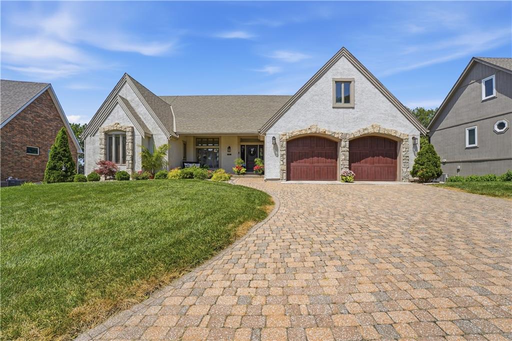 Waterfront at Raintree Lake in Lee’s Summit MO. Welcome to this beautifully updated reverse 1.5 story home on the Raymore School District side of Raintree Lake. Offering over 3,800 square feet, 4 bedrooms, 3.5 baths, and stunning lake views, this home blends thoughtful updates with the lifestyle you've been dreaming about.The main level features a spacious primary suite with a completely remodeled bath, beautifully refinished hardwood floors with new hardwoods added where carpet once existed, plantation shutters sprinkled about,  and new light fixtures. The laundry room is also located on the main level and conveniently doubles as a walk-in pantry, creating both function and style. Major improvements including a brand-new HVAC system, newer roof (under 10 years old), new front door, and new garage doors…providing peace of mind.The walkout lower level offers three additional bedrooms, two full baths, a large family room, bar area, and a versatile bonus room perfect for a home gym, hobby room, craft space, or office. Storage is plentiful with a third garage tucked around back, ideal for lawn equipment, lake toys, or additional storage.Sitting under the deck will quickly become one of your favorite parts of the home. Watching boats come and go, and all the wildlife the lake brings.Raintree Lake is a true lake community! Currently, a wide variety of water sports and activities are allowed including kayaking, paddle boarding, boating, wake surfing, water skiing, tubing, swim team and wakeboarding. And of course..Fishing! If you don't own a boat, you can rent one of the two pontoons from the clubhouse. The activities and events in this neighborhood are plentiful- Something for everyone. A neighborhood favorite are the walking trails around the lake. The Events committee also hosts Food Trucks at the Clubhouse throughout the Summer. You will also enjoy a fireworks show on the 4th of July, a bike parade, Photos with Santa, Fishing Derbies and lots and lots of clubs.