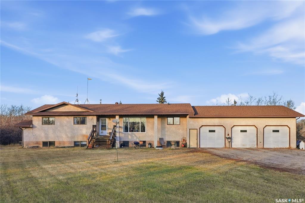 Only 6 km from Saskatoon’s city limits and a short 7 km bus ride to Montgomery School, the Merrill School Road Acreage blends wide-open country freedom with city convenience. Spanning 70 beautifully treed acres—with an additional 80 acres available directly behind for a full 150-acre package—this rare property is a private sanctuary surrounded by pasture, mature shelterbelts, and abundant wildlife. Ideal for horses, a hobby farm, or long-term investment, the back 80 acres are fully fenced and ready for hay or livestock, while the front features towering trees, a fenced garden, and pastures once home to sheep, pigs, horses, and cattle. Nestled among the trees, the 1838 sq ft raised bungalow exudes warmth and craftsmanship, with pristine oak cabinetry, vaulted ceilings, and maple hardwood floors. The bright country kitchen opens to a formal dining room with newer windows, creating an inviting family gathering space. The main floor offers three bedrooms—including a vaulted master with ensuite potential—a four-piece bath, and a second bath off the mudroom. The lower level adds more bedrooms and a non-conforming suite with its own kitchen, bath, laundry, and separate entrance—perfect for extended family or rental income (currently $1,000/month). The heated triple garage, with 11-foot walls, provides excellent space for vehicles or a workshop. Comforts include natural gas, central air, high-efficiency furnace (8 years old), backup generator, soft water from a reliable well, large hot water tank, and septic pump-out system. Outside, enjoy the sturdy deck, fenced backyard, corrals, and open space to roam. Power is underground to the front parcel, and the sandy, well-draining soil with its mix of pasture and trees makes this land ideal for countless uses. Properties of this size and seclusion, yet so close to the city, are seldom found—Merrill School Road Acreage offers the space to grow, breathe, and live your country dream.