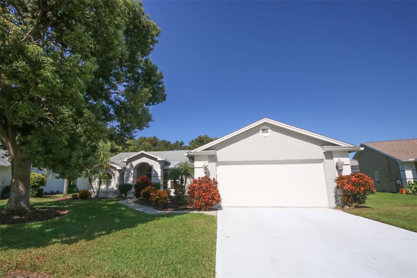 Welcome to this truly one-of-a-kind 3-bedroom, 3-full bath home situated in the highly sought-after Estates community of Hudson! This home features an open and split floor plan, ideal for both comfortable living and entertaining. Perfectly positioned near the Clubhouse, you will have easy access to newly renovated recreational amenities and a stunning pool—making relaxation and fun just steps away from your front door. Step inside to find airy, lofty ceilings, elegant, recessed lighting, and an abundance of windows that fill each space with natural sunlight. The open-concept layout seamlessly connects the living areas, while neutral colors, laminate and ceramic flooring, and marble windowsills add refined touches throughout. The remodeled kitchen is a chef’s dream, boasting granite countertops with a breakfast bar, stylish new cabinets, and top-of-the-line stainless-steel appliances. Enjoy your morning coffee at the dedicated coffee bar, complete with a bar fridge and space for a dinette table that overlooks the tranquil backyard. A spacious storage area off the kitchen provides ample room for all your extra items. The family/dining room combo features a convenient coat closet and is perfect for hosting gatherings. For even more entertaining space, this area flows into a versatile bonus room and a full bathroom, ideal for guests or as an entertainment hub. Step out to the lanai, which offers acrylic windows, ceiling fans, and an outdoor patio area primed for grilling. Electrical is already set up for a hot tub, enhancing the outdoor experience! If you prefer a quiet work-from-home environment, the bonus room can easily be transformed into a spacious office. The split floor plan ensures privacy and convenience. Two bedrooms share a full bath equipped with a shower/tub combo, and one bedroom features a pocket door for direct bathroom access. Storage is plentiful, with an enormous walk-in closet, a linen closet, and an oversized linen/storage closet located near the second full bath. The primary suite is tucked away on the opposite side of the home, offering its own walk-in closet and a luxurious en-suite bathroom. The en-suite boasts dual vessel bowl sinks, a step-down ceramic tiled shower with recessed lighting, and plenty of space to unwind. Ceiling fans installed throughout the home for year-round comfort, dual-paned windows for noise reduction and energy efficiency, marble windowsills and elegant fixtures, open and split layout for flexible living arrangements Enjoy all the perks of living in The Estates, with close proximity to the Clubhouse’s newly renovated recreational facilities and swimming pool. Whether you prefer family gatherings, quiet evenings, or hosting friends, this home’s unique floor plan is designed to meet your needs. Don’t miss your opportunity to own this truly exceptional home in Hudson. With its distinctive features, modern upgrades, and unbeatable location, this property is one in a million! Call today for your showing!