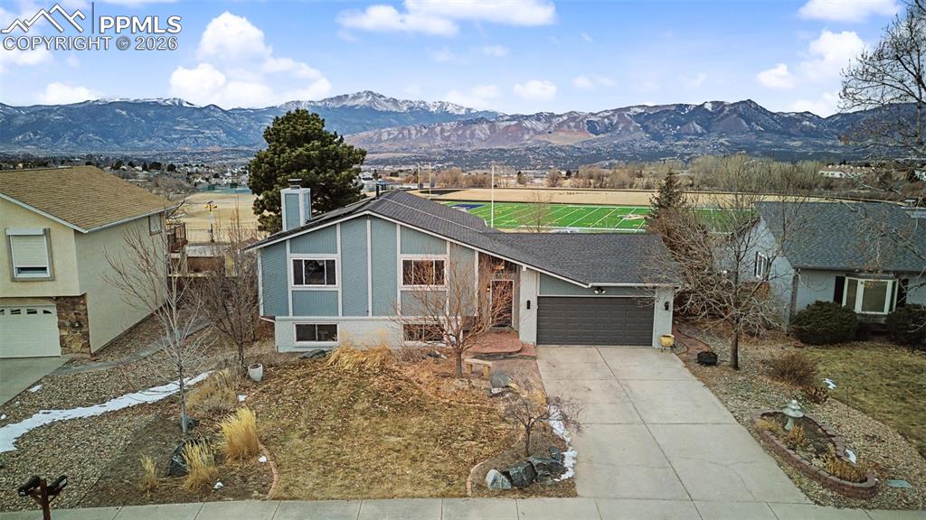This beautifully maintained 4-bedroom home sits on a spacious 10,293 square foot lot in the highly sought-after District 20 school area and offers truly unobstructed, one-of-a-kind views of Pikes Peak and the entire Front Range right from the back of the home. This recently updated kitchen features granite countertops and stainless steel appliances, while the main-level family room features vaulted ceilings and natural wood floors, creating a warm and inviting atmosphere. Downstairs, the lower-level family room is the perfect gathering space with a stone-faced wood-burning fireplace and custom built-in shelving. Both bathrooms have been tastefully updated with tile floors and granite counters. Energy efficiency is a bonus with solar panels that will be paid off at closing. The backyard is designed for both relaxation and entertaining, featuring a composite deck, a large paver patio, a hot tub with mountain views, and a storage shed. Backing directly to Rampart Park, a seventy-eight-acre park offering a fenced dog park, BMX bike track, walking paths, disc golf course, and more! This home combines comfort, updates, and an unbeatable setting.