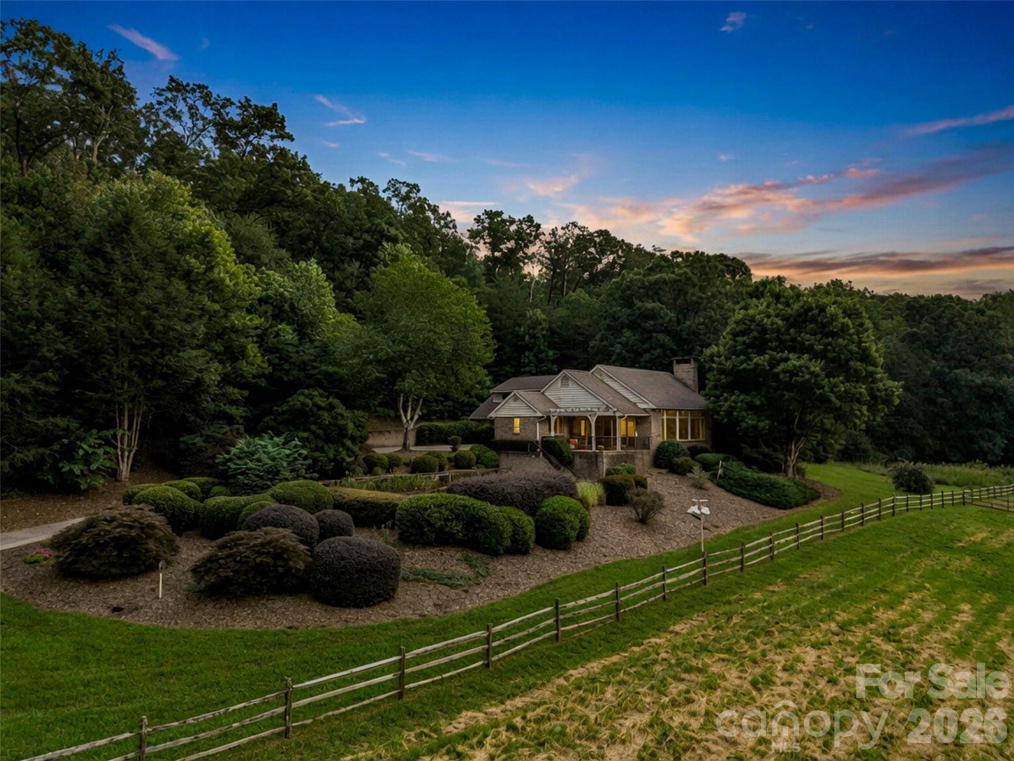 Tucked behind the gates of Brights Creek, yet free from Brights Creek restrictions, this exceptional 35-acre equestrian estate offers the rare combination of privacy, flexibility, and horse facilities. The property features four fenced pastures, four run-in sheds, a covered riding arena, and Brights Creek flowing through the land, all framed by beautiful mountain views. The well-appointed equestrian facilities include a 6-stall barn with tack room, feed room, hay loft, wash stall, and bathroom, plus a large Morton building for tractors and equipment. The 3-bedroom main residence is complemented by a separate 2-bedroom barn apartment with its own detached garage, providing ideal accommodations for guests, trainers, or rental income. A truly one-of-a-kind property designed for the equestrian lifestyle. Membership can be purchased to Brights Creek. 14 miles to Tryon International Equestrian Center.
