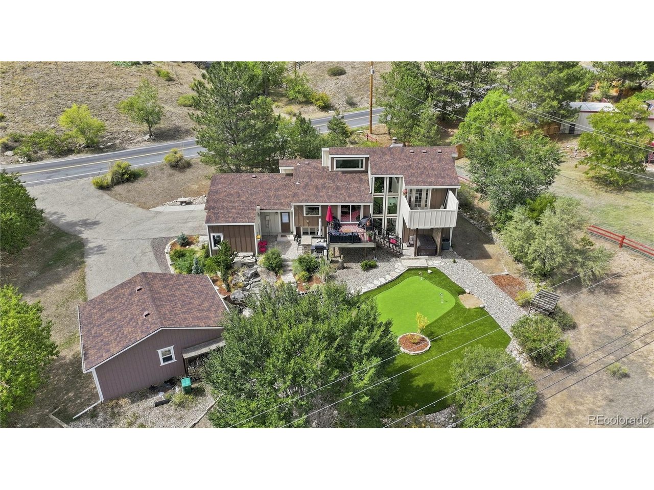 *OPEN HOUSE Thursday 9/10 5-7pm* Experience a home that feels like a private mountain retreat while remaining just minutes from the conveniences of Loveland. Tucked into Namaqua Hills, this distinctive mid-century modern inspired residence showcases beautiful architectural angles, abundant natural light, & an exceptional use of space. With a setting that feels tucked away from it all, yet offers easy access to the city & a short drive to Estes Park & the Rocky Mountains, outdoor adventure is always within reach. Inside, the thoughtful design creates a seamless connection between the home & its natural surroundings. An atrium-inspired portion of the home brings the outdoors in, with beautiful trees growing within the living space & adding an unforgettable sense of character. Expansive windows, unique angles, & natural light create an inviting atmosphere throughout the home. Designed for both everyday living & entertaining, the home offers spaces that invite you to stay awhile. Gather for movie nights in the in-home theater, enjoy a drink at the downstairs bar, or make memories in the pool room. The primary suite provides a peaceful retreat of its own, featuring a spacious walk-in shower & private balcony where you can step outside & take in the beautiful surroundings. Step outside & discover a backyard oasis designed for enjoying Colorado living. Multiple areas provide space to relax, entertain, & play, including a putting green, tranquil water feature, outdoor grilling area, & a separate structure complete with an indoor bar, perfect for hosting friends & gathering long into the evening. Beautiful views & mature trees complete the setting, creating a private outdoor escape that feels worlds away. Unique, thoughtfully designed, & full of character, this Namaqua Hills home offers more than a place to live, it offers a lifestyle. A little mountain feel close to the city, with space to entertain, unwind, & enjoy everything Northern Colorado has to offer.