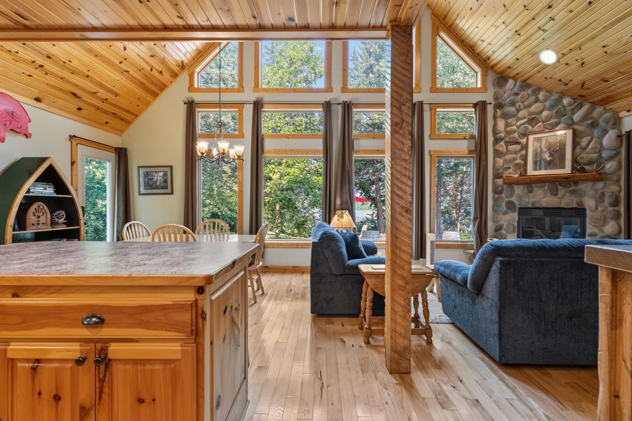 TO-BE-BUILT Scandinavian-inspired A-frame by Gallus Homes on nearly 1/2 acre with easterly views over Clear Lake—imagine starting each morning with the sunrise over the water! Designed to capture the setting, this distinctive lake home features a dramatic wall of glass, warm knotty-pine finishes and an open, light-filled interior with an impressive vaulted ceiling reaching approximately 20 feet at its peak. The main living area is anchored by a beautiful Cornerstone fireplace with stone surround, while an open staircase with log handrails leads to an upper-level loft overlooking both the great room and lake beyond. The thoughtfully designed upper level offers a full bath, additional loft/sleeping space and an expansive vaulted second bedroom extending over the garage. Knotty-pine cabinetry and trim bring warmth to the kitchen, complemented by stainless steel appliances, LVP flooring, recessed lighting and tiled bathrooms with knotty-pine vanities and cultured-marble countertops. Enjoy the outdoors from the 6x32 covered porch and take in the peaceful lake setting in every season. Exterior finishes include LP SmartSide on the front elevation with vinyl siding on the sides and rear. The insulated, sheetrocked and fire-taped 2-car attached garage includes an insulated garage door and automatic openers. City sewer, private well and 150-amp electrical service. A striking combination of Scandinavian-inspired design, natural materials and Minnesota lake living—offered as a complete to-be-built home and homesite package on Clear Lake.  Love the design, but already own your homesite?  Reach out for opportunities to build this scandinavian-inspired A-frame on your own piece of paradise.