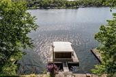 Stunning Lakefront Retreat with Wall of Windows & Vintage Boathouse on Lake Lotawana!
Welcome to your dream lake home! This beautifully designed residence offers sweeping, unobstructed views of the main body of Lake Lotawana through a dramatic wall of windows that floods the home with natural light and captures breathtaking sunrises year-round.
The main level features soaring vaulted ceilings and an expansive open-concept layout, seamlessly connecting the living, dining, and kitchen areas—perfect for entertaining or quiet lakefront relaxation.
Upstairs, a spacious loft bedroom with a full private bath provides a cozy yet open retreat overlooking the main living space and the sparkling lake beyond.
The finished lower level offers additional living space with a walk-out that leads to your private lakeside oasis, complete with stairs descending into deep, clear water, ideal for swimming or boating. A charming vintage boathouse adds unique character and functionality, ready for your water toys or lakeside lounging.
Whether you're seeking a weekend getaway or full-time lake living, this rare offering blends charm, comfort, and unbeatable views in one of Lake Lotawana's most desirable locations.

Price Adjustment just for you!