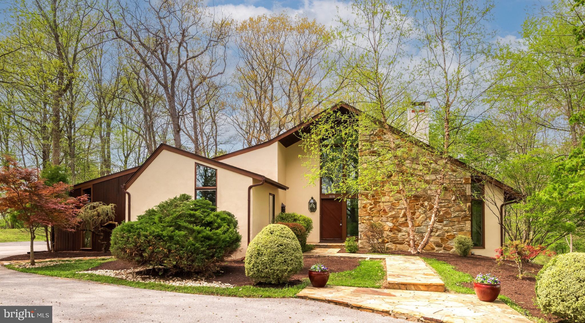 Welcome to 1038 Hersheys Mill Road, a beautifully spacious 5 bed, 3 full and 2 half bath home nestled on a private and picturesque 3.4-acre lot in the highly desirable Hersheys Mill Estates community—this is NOT the 55+ community. This exceptional property offers the perfect balance of serene privacy and access to incredible neighborhood amenities, including pools, tennis and pickleball courts, a playground, tot lot, and scenic walking trails. As you make your way up the driveway, you’re welcomed by peaceful wooded views that set the tone for what’s inside. Step into the impressive two-story foyer, highlighted by a stunning mural, and continue into the breathtaking living room featuring soaring ceilings, a dramatic wall of windows. To the left of the foyer, a private wing offers incredible versatility with a library showcasing a large glass-enclosed bookcase, a convenient half bath, and a dedicated office complete with its own exterior entrance—ideal for working from home or hosting clients.  To the right of the foyer you will find the oversized living room with continued cathedral ceilings featuring a stone-wall wood-burning fireplace. The main level continues with a generously sized dining room filled with natural light, perfect for gatherings of any size. The updated eat-in kitchen is equipped with a gas cooktop, granite countertops, and beautiful backyard views, along with direct access to a multi-level stone patio, hot tub, shed, and wooded surroundings. Just off the kitchen, the cozy family room has a gas burning fireplace, creating a warm and inviting atmosphere. The main floor primary suite offers a peaceful retreat with access to a private deck, a walk-in closet, and an en-suite bath complete with a jacuzzi tub, a walk-in shower, and double vanity. An oversized laundry/mudroom adds convenience with direct access to the backyard and hot tub area. Upstairs, you’ll find three spacious bedrooms, all with fresh carpeting, and a full hall bath. The fully finished lower level expands the home’s flexibility with a fifth bedroom, full bath, additional living space, and abundant storage. With its own walk-out access, this level is ideal for an in-law or au pair suite, guest quarters, game room, or whatever suits your lifestyle. Additional highlights include a spacious 3-car garage, abundant indoor and outdoor living areas, whole-house vacuum and a layout designed for both entertaining and everyday comfort. Whether you love hosting or simply relaxing in your own private retreat, this home offers it all—and has been fully inspected for added peace of mind. Located within a sought-after community and served by outstanding schools, this home is just minutes from the charm of West Chester and Malvern, offering easy access to fantastic shopping, dining, and everyday conveniences. A truly special opportunity to own a one-of-a-kind property in an exceptional location. Schedule your private showing today!