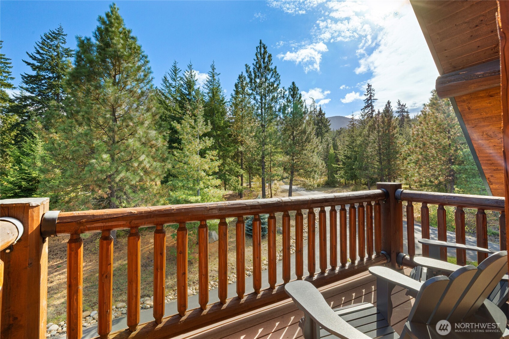 One of the home’s four porches, this upper-level outdoor space offers a quiet place to take in the surrounding forest and mountain setting.