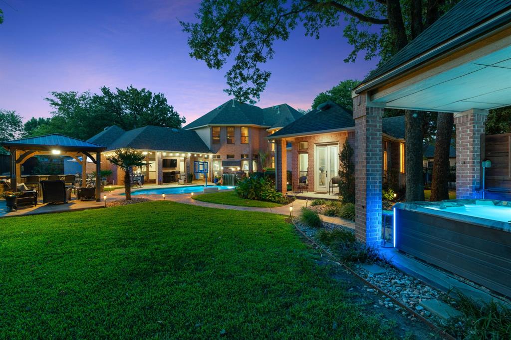 Luxury Living in a Private Gated Community – Priced to Sell Quickly!

Discover this exceptional home in an exclusive gated enclave of only 11 custom residences. Set on a .71-acre cul-de-sac lot, the property welcomes you with a porte cochère entry, private electronic gate, stately NASA-style pillars, and lush landscaping that set the tone for elegance and privacy.

Inside, soaring ceilings, abundant natural light, and a dramatic dual staircase create an impressive welcome. Designed with both comfort and entertaining in mind, the home blends custom detail with modern updates.

The backyard is a true oasis. Enjoy a resurfaced pool with grotto waterfall, separate hot tub under a brick gazebo with Bluetooth-enabled sound and lighting, and three patios for outdoor living. The main poolside patio features its own electrical system, ceiling fan, stone bar, fire pit, and seating area. Professional up-lighting highlights the trees and fence line, while a 180-ft cedar fence (2019) ensures complete privacy.

Interior upgrades include a primary suite with glass shower and smart electric toilet, and an upstairs Jack & Jill bath redesigned with a walk-in glass shower. A whole-home sound system, rewired in 2019 and 2021, offers speakers throughout and integrates seamlessly with the outdoor system — all controlled by cell phone.

This property combines custom craftsmanship, thoughtful upgrades, and resort-style amenities in one of the area’s most private enclaves —