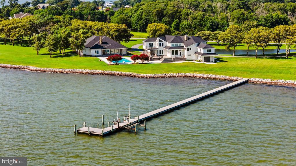 A Rare Opportunity to Own an Exceptional Waterfront Estate.  Nestled in the prestigious South Point Farms community, this breathtaking 6.39-acre waterfront estate presents a once-in-a-lifetime opportunity to experience unparalleled luxury, privacy, and natural beauty. With its peninsula-style bayfront setting and an expansive 700 feet of direct waterfront, this property offers a truly unique waterfront lifestyle—one where history, tranquility, and modern conveniences converge to create the ultimate coastal retreat.Designed for effortless indoor-outdoor living, the estate features a magnificent main residence, a spacious guest house, and an oversized detached garage/work-shop, all perfectly positioned to capture sweeping, unobstructed views of the bay. Whether you're drawn to the peaceful serenity of a quiet morning by the water or the thrill of high-speed boating adventures, this property offers the best of all worlds.-- THE MAIN HOME, spanning an impressive 4,165 square feet, is a masterpiece of thoughtful design and elegant craftsmanship. Nearly every room is graced with panoramic water views, allowing you to fully immerse yourself in the beauty of the bay. The home features:Four spacious bedrooms and four and a half baths.A grand great room with soaring ceilings and a traditional fireplace.A professional chef’s kitchen.Two dedicated home offices.A sitting room and dining area that seamlessly blend comfort with sophisticationAn attached bay-facing garage, ideal for water toys and gearMultiple IPE Brazilian hardwood decks, perfect for soaking in the waterfront ambiance.A newly installed roof on both the main and guest houses.  -- THE GUEST HOUSE: Just steps from the main house, a 1,619-square-foot guest house offers an additional retreat for family and friends. Featuring two bedrooms, a full bath with a sauna, a vaulted wood ceiling family room with a fireplace, and a professional-grade kitchen with a breakfast bar, this space is ideal for hosting guests in comfort and style. Overlooking the shimmering 50’ x 24’ bay-facing in-ground pool, the guest house serves as a private sanctuary & guest oasis.  Unwind in the fully-conditioned Guest House garage & game room, complete with pool table and more.  UNMATCHED OUTDOOR AMENITIES:   For those who love life on the water, this estate is a dream come true. A 250-foot pier/dock provides ample space for mooring boats (with a lift) offering quick access to the bay.  Over 700 feet of newly installed rip-rap along the shoreline ensures years of worry free waterfront living.  ADDITIONAL OUTDOOR HIGHLIGHTS:A large spa-inspired outdoor pool-side full-bath, perfect for rinsing off after a day on the waterBeautifully landscaped grounds featuring a half-acre pond A spacious IPE wood deck ideal for crab feasts and alfresco diningA circular driveway providing a grand entrance to the estateTHE BEST OF ALL WORLDS: Serenity, Convenience, and AdventureWhile this estate offers a private, peaceful escape, it is also ideally situated near some of the Eastern Shore’s most beloved destinations. Just minutes away, Assateague Island National Seashore awaits with its pristine beaches, wild ponies, and breathtaking coastal scenery, offering a nature lover’s paradise. The historic charm of Downtown Berlin, named America’s Coolest Small Town, is also close by, featuring boutique shopping, fine dining, and vibrant cultural events. For those seeking excitement, the bustling beaches and boardwalk of Ocean City are just a short drive away, providing endless entertainment, renowned restaurants, and world-class golf courses.A  LEGACY OF COASTAL LUXURY:This estate is more than just a home—it is a rare and extraordinary opportunity to own a tasteful waterfront retreat that will never be matched. Whether you're looking for a luxurious year-round residence or a private coastal getaway, this exceptional property promises a lifetime of opportunity and enjoyment.