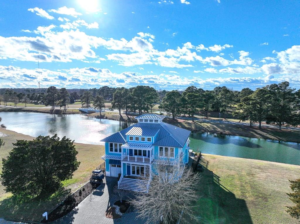 WATERFRONT in Bay Creek “Bahama Blue” – Grand Bahama–style contemporary w/4 primary en suites & 2 garages. Complete renovation 3 years ago w/ new appliances & interior/exterior paint. Enjoy resort living w/captivating water views & Bay Creek community amenities; pool, beaches & tennis. Golf membership is optional. This coastal living home is being offered fully furnished...ready to move in or book for vacation rentals. Built for entertaining: 11' island w/ dual wine fridges, under-counter commercial ice maker, upstairs mini bar, & open-concept living. Two screened porches & a 14' swim spa overlooking lake sunsets. Security system, irrigation from pond, whole-home water manifold, dedicated mechanical room, 3 owner closets, cove lighting throughout. Marina slips available. Golf cart to town.