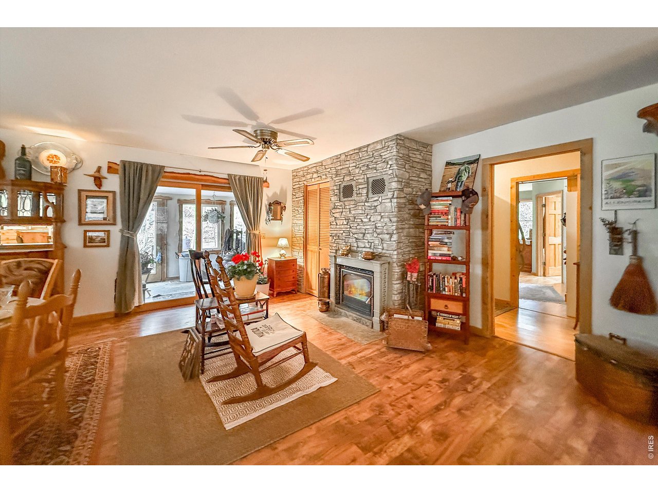 Set along the sunny side of picturesque Riverside Drive, this rare 1.6-acre mountain retreat offers an exceptional combination of privacy, water, flexibility, and easy year-round access. Although across from the South St. Vrain River, the river is beautifully present - seen and heard from the home and two south-facing balconies. A long-established waterway runs through the backyard alongside a peaceful pond, creating a lush, private outdoor oasis deeply connected to the landscape. Inside, the remodeled open kitchen features custom soft close knotty alder/maple/walnut cabinetry by local artisan & wood worker Susan Maxson. Granite counters, a large gathering island, and a dual-fuel oven, all framed by three large windows overlooking the lush landscaping. The living room's wood-burning fireplace is both a charming centerpiece & capable heat source for the home, complementing the boiler system - and the screened-in balcony just off the living room is the perfect place to relax to the sounds of the river. The spacious main-floor primary suite is a true spa-like retreat, featuring a gas fireplace, bay window, steam shower, rough-in for a soaking tub, and a connected breezeway with 220V ready for a future hot tub. A secondary bedroom enjoys its own private balcony with river views. The walkout lower level offers a large third bedroom or family room with half bath, workshop with exterior entrance, attached one-car garage, and generous storage. A separate cabin with propane, electric, water, and septic opens wonderful possibilities as a guest retreat, studio, office, or potential rental - buyers should verify uses with Boulder County. A detached garage with carport provides space for vehicles and mountain gear, while satellite internet supports modern life and work-from-home flexibility. Both the main home & cabin enjoy easy paved-road access. All of this just 20-30 minutes from Lyons and Boulder, yet feeling like a world away. An unbeatable combination all in one property!