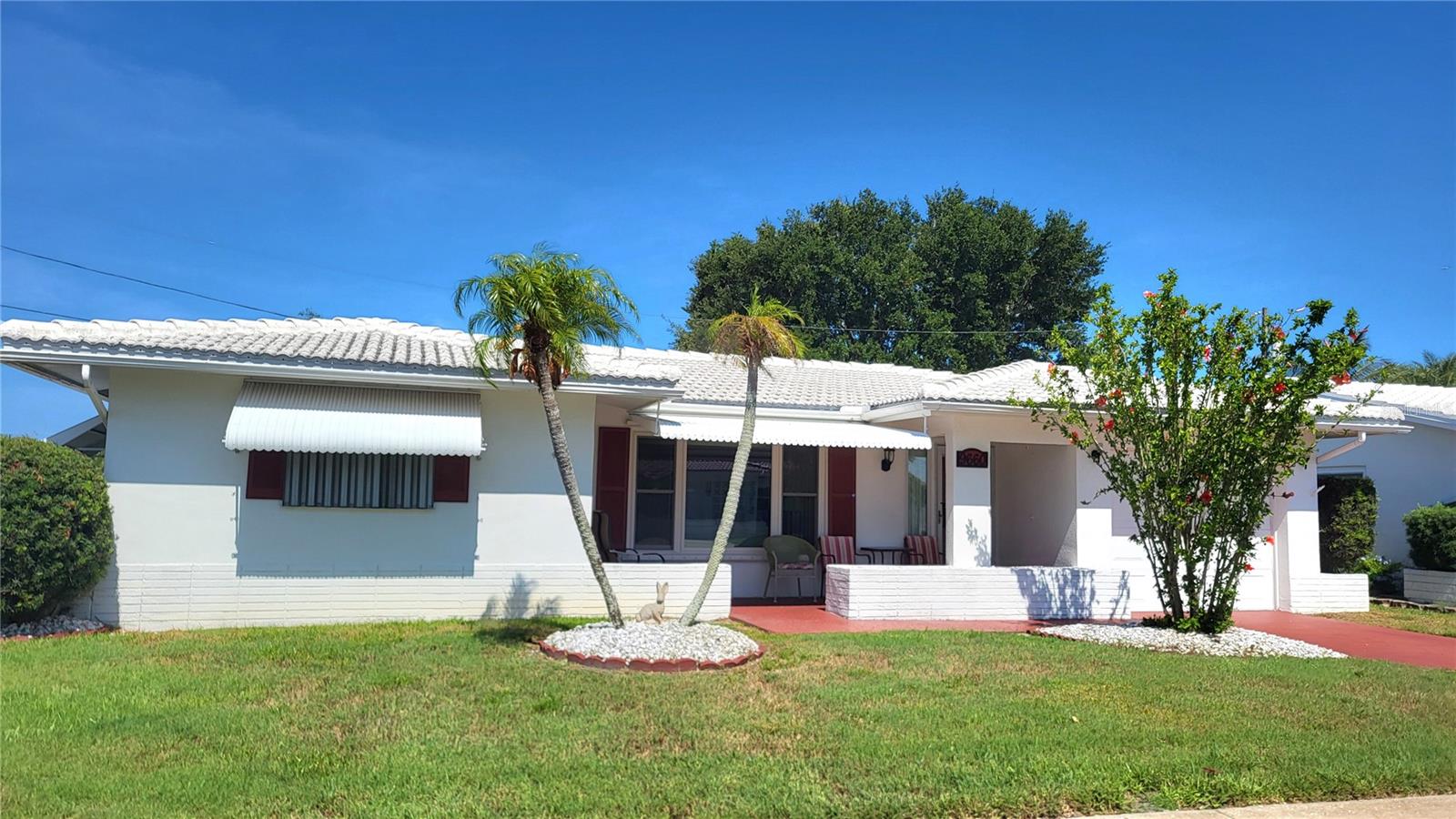 Come and see this home that sits on a nice corner lot in a golf course 55+ community. There are 2 living centers for extra privacy and for that added feeling of spaciousness.   This home has floors with the look of wood and comes completely furnished down to the towels and spoons.  The tile roof was put on in 2022.  20% of the owners can be under 55.  Large pets are ok.
