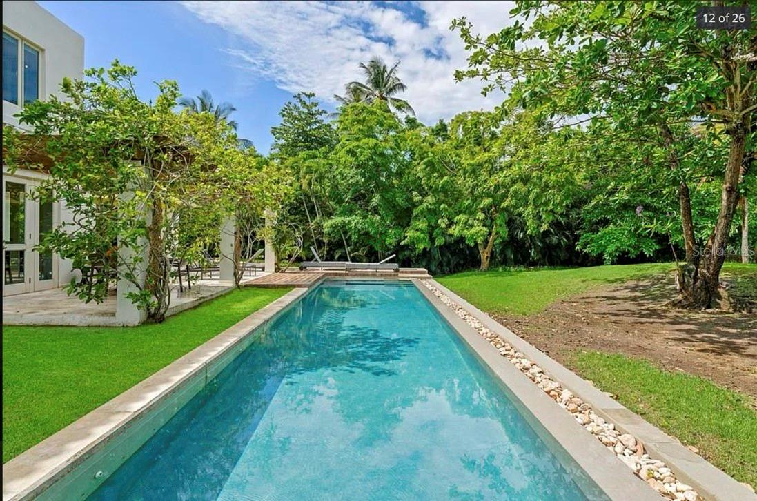 Tucked away at the end of a quiet street in Dorado Beach East, this beautifully maintained residence enjoys a peaceful setting surrounded by nature. Overlooking a tranquil pond and bordering a lush community green area with a charming putting green, the property offers a wonderful sense of privacy. Mature trees frame the backyard, creating a serene backdrop where the open green space feels like a natural extension of the home's outdoor living areas.From the moment you enter, soaring ceilings and abundant natural light create a bright, welcoming atmosphere. Elegant marble floors flow throughout the home, while the remodeled kitchen features premium Sub-Zero and Wolf appliances and opens seamlessly to the main living spaces, making it equally suited for everyday living and effortless entertaining. Just off the dining room, a wine cellar adds both character and functionality, making it a wonderful feature for those who enjoy hosting family and friends.The home's thoughtful layout offers exceptional flexibility. A spacious first-floor bedroom, nearly the size of the primary suite, is ideal as a guest suite, multigenerational space, or second primary bedroom.Upstairs, the expanded primary suite offers a peaceful retreat with a spacious spa-inspired bathroom, an oversized walk-in closet, and a private terrace overlooking the surrounding greenery. Two additional bedrooms feature vaulted ceilings, abundant natural light, and share a well-appointed bathroom. The laundry room is also conveniently located on the second floor.The main residence offers 4,224 square feet of interior living space, complemented by a detached 293-square-foot guest suite with a full bathroom, ideal as a guest bedroom, home office, fitness room, flex space, or creative studio. Total construction of the home is an impressive 6,383 square feet.The expansive covered terrace, beautifully landscaped backyard, and swimming pool create the perfect setting for everything from quiet mornings outdoors to weekend gatherings with family and friends, all surrounded by the beauty and tranquility of the mature landscape.Combining elegant finishes, generous living spaces, a versatile floor plan, and a unique connection to nature, this residence offers an exceptional opportunity to enjoy the relaxed lifestyle of Dorado Beach East, whether as your next home or an outstanding luxury rental.