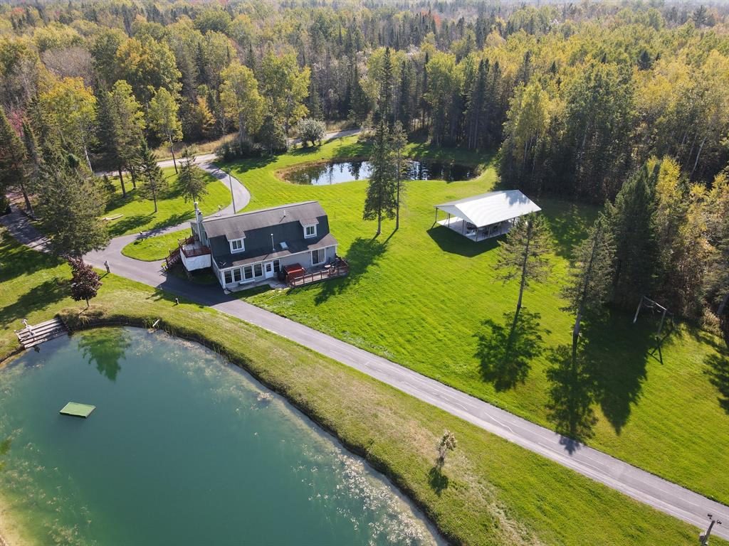 Northern Michigan 80-acre secluded paradise! Located in Alpena County this 5 bed 2 bath home features a huge sunroom, wood burning fireplace, outside access to the upstairs master bedroom and deck, concrete patio, large mudroom entryway, newer flooring in the living room and Generac generator for backup power. Outside you find 3 ponds one that is spring fed with a nice swimming area and raft. Alongside the home is a large pavilion with concrete, perfect for family gatherings or just sitting out enjoying the surroundings. The circular asphalt driveway was seal coated this summer also leads back to the pole barn. The barn features one sliding door, one overhead door, a walk in door with concrete and power. Great for all your toy and equipment storage. As you make your way back into the woods you will find a nice trail system for access around the front 40 ac. that consist of mostly Fir, Cedar, Poplar and Maple trees with a creek cutting through the middle of the property. Whether you are looking for secluded year round living or a family & friend hunting camp this place will check all those boxes! Located about 3 miles from M-65 near Beaver Lake and approximately 20 miles from Alpena for all your amenities. Call today for your private tour of this Pure Northern Michigan property!