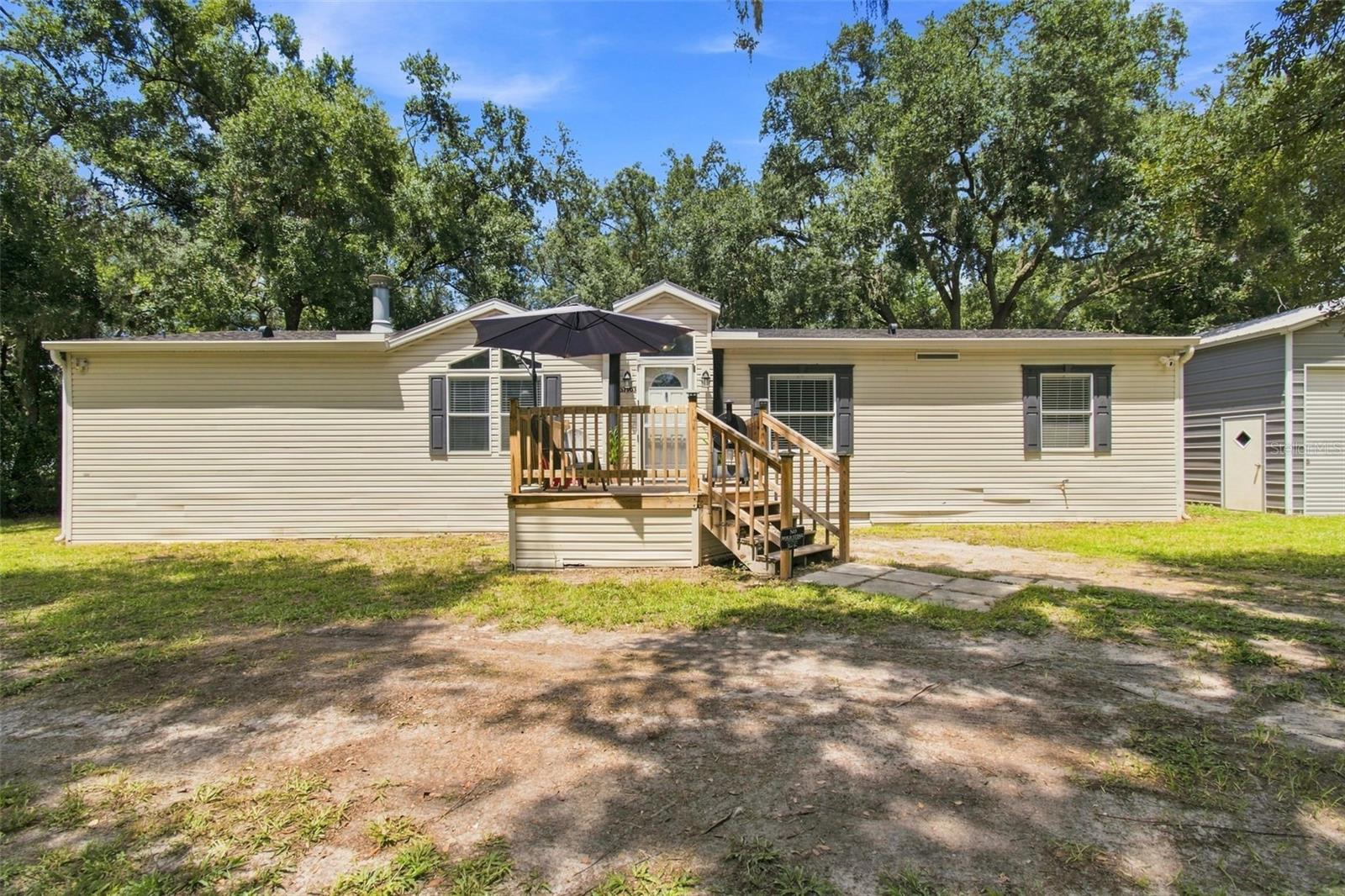 SPACE. PRIVACY. FREEDOM. Welcome home to this spacious 3-bedroom, 2-bath residence situated on approximately 1.17 FULLY FENCED ACRES in Zephyrhills! Surrounded by mature trees and offering plenty of room to spread out, this property delivers a wonderful combination of privacy, comfortable living, and usable outdoor space.Step inside to approximately 1,728 square feet featuring an inviting OPEN FLOOR PLAN, cathedral ceilings, and abundant natural light. The spacious kitchen serves as the heart of the home with crisp white cabinetry, generous counter space, stainless steel appliances, and an oversized breakfast bar perfect for casual dining, entertaining, or gathering with family and friends. The kitchen flows seamlessly into the dining and living areas, where a WOOD-BURNING FIREPLACE creates a warm and welcoming focal point.The SPLIT-BEDROOM FLOOR PLAN provides added privacy, while the spacious primary suite offers a comfortable retreat with plenty of room to unwind. An inside laundry area adds everyday convenience.Step outside and discover what truly sets this property apart—approximately 1.17 FULLY FENCED ACRES surrounded by beautiful mature trees. There's room for pets, gardening, outdoor activities, recreational toys, hobbies, or simply enjoying your own private slice of Florida. Start your mornings with coffee on the front deck or relax beneath the shade of the surrounding trees at the end of the day.Need additional storage or workspace? The LARGE DETACHED GARAGE/WORKSHOP provides valuable extra space for vehicles, tools, equipment, projects, and more.Adding even more value and peace of mind, the property is located in FLOOD ZONE X, where flood insurance is typically not required by lenders.With SPACE both inside and out, this Zephyrhills property offers a hard-to-find combination of ACREAGE, PRIVACY, FUNCTIONALITY, and FREEDOM—all while providing a comfortable place to call home. Schedule your private showing and come experience the possibilities for yourself!