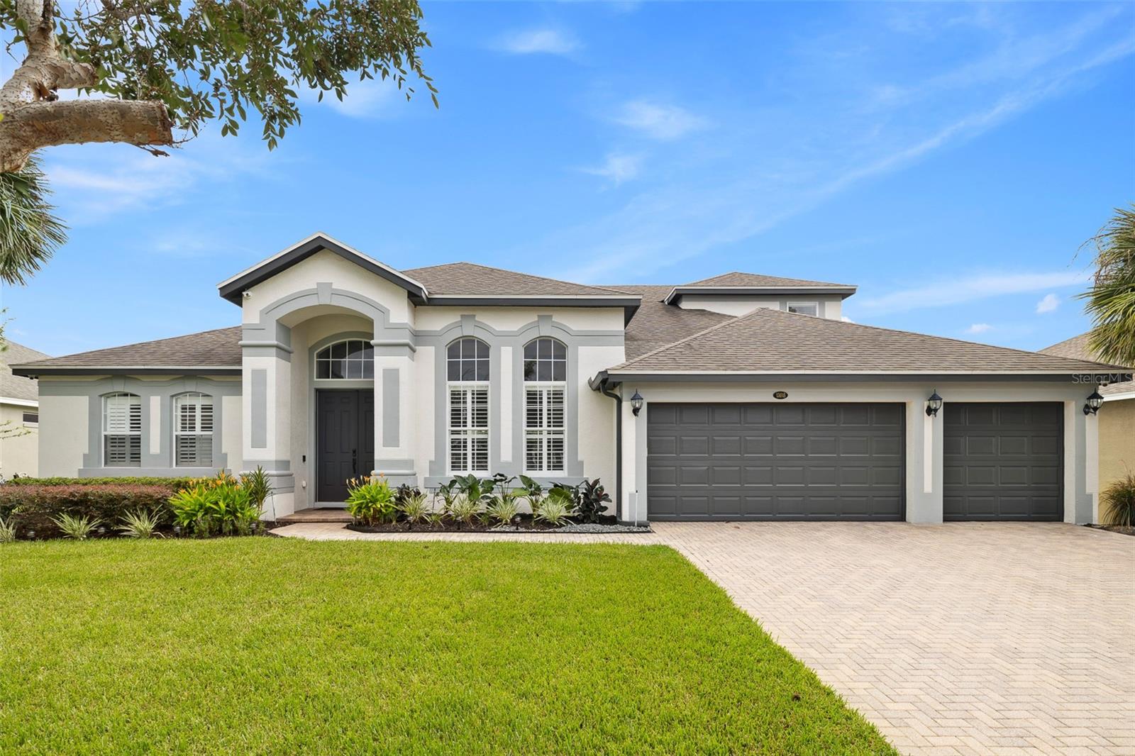 Virtually Staged. A true pride-of-ownership home showcasing architectural elegance, extensive upgrades, and the ultimate Florida lifestyle! Welcome to this stunning Winter Garden residence featuring a freshly painted exterior, tropical landscaping, paver driveway, and spacious three-car garage. Inside, soaring 13.5-foot ceilings, architectural arches, double-tiered tray ceilings, and a custom coffered family room ceiling create an impressive atmosphere. The gourmet kitchen features a sprawling granite island with prep sink, 42-inch solid wood cabinetry custom-painted in November 2025, premium GE Profile stainless steel appliances, a cooktop, double ovens, and a separate butler’s pantry ideal for entertaining or a coffee station. Enjoy seamless indoor-outdoor living through 16-foot, four-panel sliding pocket doors opening to a spacious brick-paver, screened lanai. Relax beneath the covered patio with flush-mounted speakers or beside the oversized saltwater pool with a new variable-speed pump installed in October 2025. The private quarter-acre backyard features mature privacy hedging and a convenient pool-access bathroom with a glass-enclosed walk-in shower. The main-level primary suite offers an elegant tray ceiling, a custom walk-in closet system installed in February 2026, and luxury linen and blackout window treatments. More than $100,000 in reported premium upgrades enhance comfort, efficiency, and peace of mind. Improvements include a 2-ton Daikin 15.6 SEER2 HVAC system (September 2025), upgraded R-38 attic insulation (September 2025), zoned 5-ton variable-speed Trane HVAC. Whole house hot water hybrid system: Tankless water heater fed by propane tank as a main source (electric tank can be used as a back-up). Aquasure Harmony whole-house water softener (August 2024), and a roof replaced in August 2016. Smart-home features include pre-wired 7.1 family room surround sound, multi-zone audio, window-tint film, security cameras with hybrid DVR, motion-activated lighting, smart front-door and garage locks, smart thermostats, and a Rachio irrigation controller. The gated subdivision adds another layer of appeal. Located in desirable Glynwood II at StoneCrest, residents enjoy a clubhouse, resort-style pool, playground, tennis courts, and scenic walking trails with pond views, a fountain, and green spaces. Conveniently close to Winter Garden Village, shopping, dining, parks, and the West Orange Trail, the community also offers access to major roadways, Orlando’s employment and entertainment centers, world-famous theme parks, Orlando International Airport, and Florida’s beautiful beaches. Experience exceptional architecture, modern technology, privacy, and effortless entertaining in this remarkable Winter Garden home! Note: The last four photos have been virtually staged.