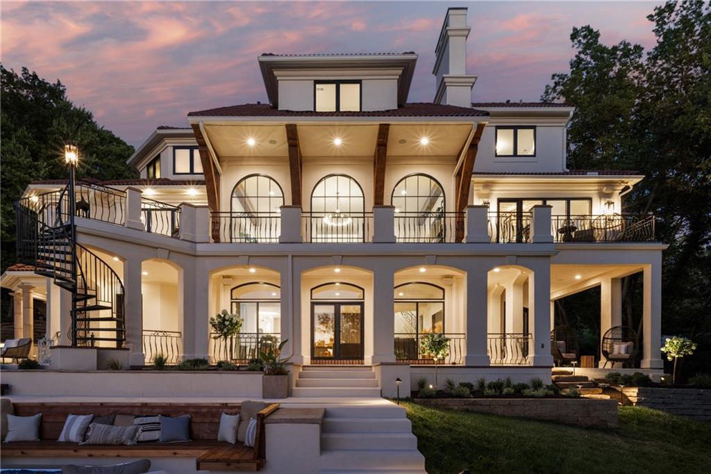 This stunning Modern Mediterranean lakefront estate is nestled among mature trees and showcases breathtaking lake views from every window. Featuring exceptional designer details and luxurious finishes, this renovated home has been completely transformed inside and out. Updates include all-new stucco, landscaping, exterior lighting, entry wall, and driveway. The resort-style backyard offers a pool with sun deck and automatic cover, putting green, fire pit, expansive patio, and elevated deck — creating the ultimate setting for relaxation, entertaining, and unforgettable sunsets. The chef’s kitchen is a showpiece, highlighted by a custom iron hood over a 60” Ilve range, Fisher & Paykel refrigerator and freezer, dual dishwashers, oversized island, walk-in pantry with custom built-ins, Advantium oven, beverage refrigerator, and a bright breakfast area. The living room features a dramatic wall of windows overlooking the lake and a striking fireplace with a full marble surround.  The private owner’s suite includes glass doors opening to the deck and a spa-inspired bath with heated floors, dual showers, and a soaking tub. The lower level offers a fifth bedroom, cigar/bourbon room, living room, glass-enclosed temperature-controlled wine room, distinctive round bar, and a sun-filled exercise/sauna room with direct pool access. Additional highlights include multiple patio spaces, a dedicated pool bath with exterior access, and four laundry rooms conveniently located in the mudroom, primary closet, upper level, and pool area. Situated on a fully fenced, beautifully landscaped, one-acre wooded lot, this extraordinary property is truly a one-of-a-kind renovation on a highly sought-after lakefront setting.