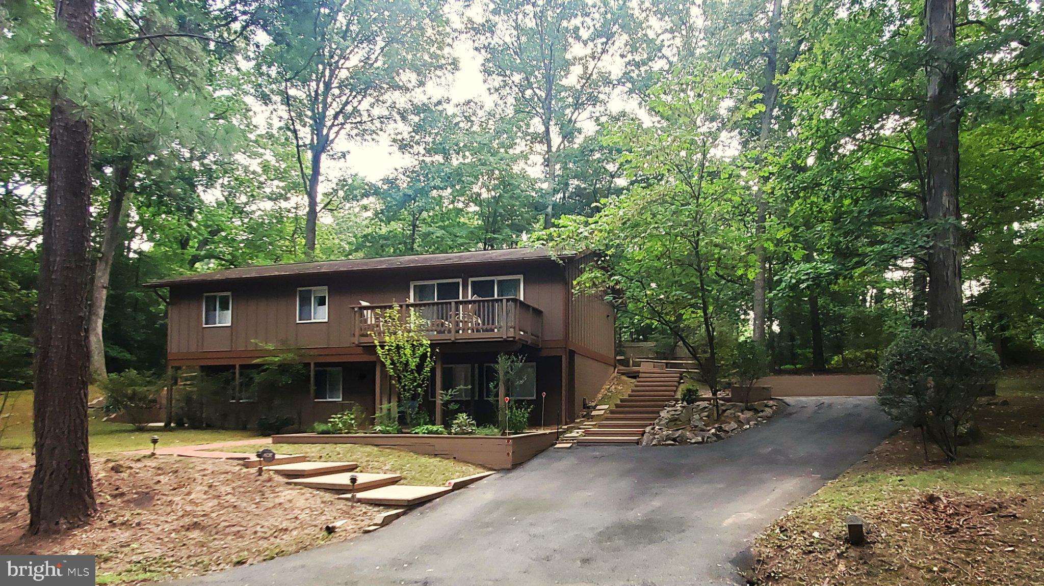 This charming residence, built in 1967, offers a harmonious blend of classic charm and nature.  The interior features an open floor plan that seamlessly connects the kitchen and dining areas, ideal for entertaining. The home boasts a main level bedroom, 3 other bedrooms, and three full bathrooms. Notable interior highlights include an attic, window treatments, and a cozy fireplace to enhance the ambiance. The exterior showcases a well-maintained wood siding façade, complemented by a private, partly wooded lot of 0.37 acres situated on a tranquil cul-de-sac. Outdoor amenities include a balcony, multiple patios, and a deck, perfect for enjoying the natural environment. Additional features comprise secure storage and ample parking options, including a paved driveway. This property is a rare find, combining comfort, style, and a peaceful setting, making it an ideal choice for discerning buyers seeking a quality home.