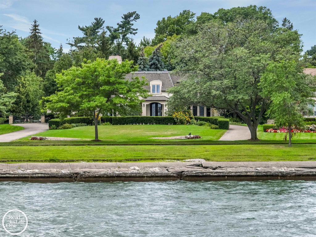 Lake Shore Living! Move right in to this stunning lake front estate in prestigious GP Shores.  Enjoy the sunrise each morning and the moon each evening over Lake St. Clair, with breathtaking views from most rooms. This home boasts incredible grand details with a very functional layout.  The foyer showcases an intricate custom iron staircase banister, glittering crystal chandelier, marble inlay flooring with matching leaded front door. Custom stained glass throughout. Imported fireplaces in living room, primary suite, and office. Fabulous inlayed African Walnut floors in the living room and dining room. The office and bedroom floors are Brazillian Cherry.  The basement is what dreams are made of, bar with banquette seating, billiard area, home theater, wine cellar with fireplace and room for entertaining, and a full spa bathroom with sauna.  3 car attached garage, with adjacent mudroom and laundry.  Gorgeous pool and hot tub with mosaic tile.  Deck area has pergola with the most spectacular mature wisteria.