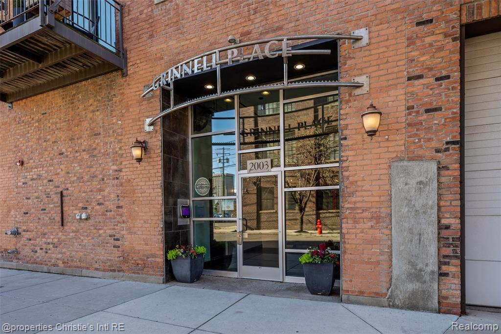 A Corktown Masterpiece: Where Historic Charm Meets Modern Loft with Epic City Views.  Discover your urban sanctuary in the heart of historic Corktown. This exceptional condo seamlessly blends industrial character with contemporary elegance. From the moment you enter, you are greeted by an awe-inspiring open-concept living space defined by its soaring 14-foot ceilings, original exposed brick, metal stairs and railings, and rustic wooden beams. Sunlight pours through magnificent 9-foot windows, illuminating the rich hardwood floors and highlighting the lofted second level that has room for a bedroom and flex lounge space equipped with bar sink and cabinet. This thoughtfully designed home features a rare and highly sought-after layout: two spacious areas for bedrooms, each boasting the privacy and convenience of a full en-suite bathroom. An additional half bath is perfectly placed for guests. The true showstopper, however, is the unparalleled access to the city's iconic skyline. Enjoy your morning coffee on the private balcony off the main living area, or entertain guests on your exclusive individual rooftop deck. From this incredible vantage point, you'll witness unobstructed, panoramic views stretching from the majestic Michigan Central station to the glittering downtown Detroit skyline, and across the river to both the iconic Ambassador Bridge and the new Gordie Howe International Bridge. This is more than a home; it's a front-row seat to the renaissance of a great American city.
