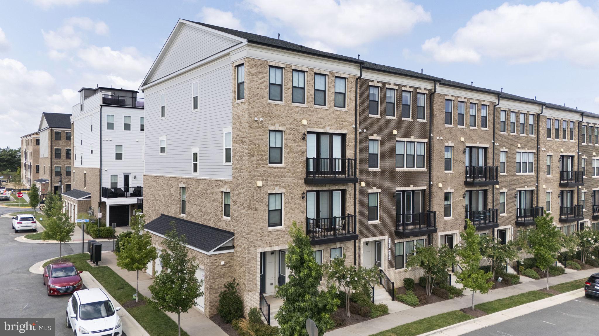 Welcome home to this stunning, 3 YEARS YOUNG Van Metre end-unit townhome-style condo in the highly sought-after Goose Creek community! Offering over 2,000 square feet of beautifully designed living space, this light-filled home features 3 spacious bedrooms, 2 full baths, and 2 half baths, thoughtfully designed for today's lifestyle. The entry level welcomes you with a versatile family room, perfect for a home office, media room, or additional living space, along with a convenient half bath and direct access to the attached one-car garage. The heart of the home is the spectacular second level, where an open-concept layout is ideal for both everyday living and entertaining. The gourmet kitchen showcases crisp white cabinetry, quartz countertops, stainless steel appliances, and a spacious walk-in pantry. The adjoining living and dining areas open to a private balcony, creating the perfect space to enjoy your morning coffee or unwind at the end of the day. Retreat to the luxurious primary suite, featuring two walk-in closets, a private balcony, and a spa-inspired ensuite bath with dual vanities. The upper level offers two additional generously sized bedrooms with ample closet space, a full bath, and convenient bedroom-level living.  Situated in the heart of Ashburn, this home offers exceptional convenience for commuters, with the Dulles Greenway and Route 267 less than one mile away and the Ashburn Silver Line Metro Station just minutes away. Enjoy everything Goose Creek Village has to offer, including popular restaurants, shopping, fitness studios, coffee shops, and everyday conveniences just moments from your front door. Residents enjoy access to outstanding community amenities, including a resort-style outdoor pool, clubhouse, tennis courts, outdoor theatre, and more.