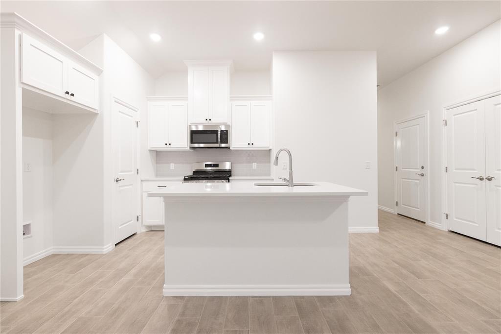 FENCING AND BLINDS INCLUDED! This John floor plan includes 1,310 Sqft of total living space, which includes 1,200 Sqft of indoor living space and 110 Sqft of outdoor living space. There is also a 385 Sqft, two car garage with a storm shelter installed. This new home offers 3 beds, 2 baths, 2 covered patios, and a utility room! The living room includes high ceilings, exquisite wood-look tile, a ceiling fan, the perfect sized windows, and Cat6 wiring. The kitchen spotlights custom-built cabinets with decorative hardware, stainless-steel appliances, decorative tile backsplash, elegant countertops, and wood-look tile. The primary suite features 2 windows, a ceiling fan, our cozy carpet finish, and a sizeable walk-in closet. Attached is the primary bath, which holds a dual sink vanity complimented by a 3 CM quartz countertop, satin nickel features, and a walk-in shower with tile to the ceiling. Outdoor living includes fully sodded yards, a smart home irrigation system, and 30-yr weather wood shingles. Other amenities include a water-saving tankless water heater, a fresh air intake system, R-15 & R-38 insulation, and so much more!