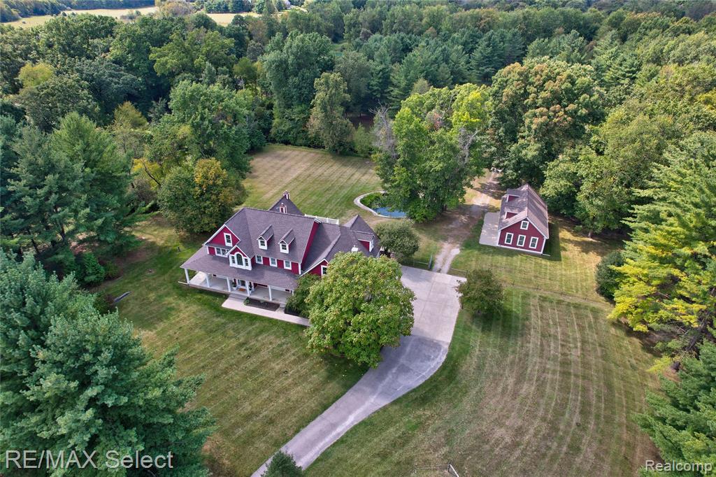 Tucked away on 10 peaceful acres, this home blends charm, comfort, and country living at its best. From the moment you arrive through the gated entry, this remarkable property sets the tone with its wraparound porch, tranquil koi pond, and winding creek with a bridge. Inside, the gourmet kitchen shines with beautiful hardwood floors and a sunny breakfast nook, while the formal dining room offers a refined space for entertaining.
The firelit living room makes a dramatic statement with soaring vaulted ceilings accented by rich wood beams, custom built-ins, and walls of natural light. A stunning 3-season room with recessed lighting and ceiling fans extends your living space in style. The primary suite is a true retreat with its own fireplace, sliders leading out to the deck, and a spa-like bathroom with a jetted tub and stand-up shower.
A full, finished walkout basement with a rec room and full bath ensures endless possibilities for relaxation and entertaining. Beyond the home, the property offers extraordinary amenities: a 3-car attached garage with loft and an additional 3-car detached garage, several paddocks, offering plenty of room for your animals to roam, graze, and play and a brand-new roof for peace of mind! A rare opportunity to own a property that combines sophistication, functionality, and breathtaking natural beauty—this estate is nothing short of exceptional.  A true sanctuary where luxury meets nature!