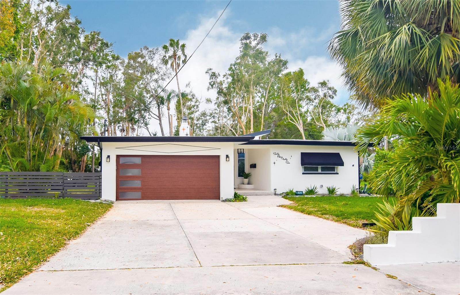 Don’t miss this stunningly restored mid-century modern home in St. Petersburg’s highly sought-after Pasadena on the Gulf Community! PERFECTLY SITUATED ON A RARE DOUBLE LOT THAT’S ALMOST HALF AN ACRE, THIS PROPERTY OFFERS OVER 1,600 SQ. FT. OF BEAUTIFULLY UPDATED LIVING SPACE AND A BACKYARD OASIS THAT’S TRULY ONE OF A KIND...AND IN A NON-FLOOD ZONE! Step inside to discover a bright, open living area with vaulted ceilings, abundant natural light from double-pane windows, and sleek luxury vinyl plank flooring in the main living areas, plus a beautiful marble foyer. Thanks to the vaulted ceilings and natural lighting, this home feels huge! The gorgeous kitchen boasts new stainless steel appliances, butcher block countertops, floating shelves, and a designer herringbone backsplash. The primary suite features a fully remodeled en-suite bath with a glass-enclosed shower, modern vanity, and beautiful lighting. 2 additional bedrooms offer flexible space, with the 3rd bedroom opening to the back patio through elegant French doors, making it the dreamiest guest suite. The spacious hall bath is equally impressive, showcasing a tub/shower combo with glass doors, stylish tilework, and updated lighting. Enjoy comfort year-round with central A/C, a BRAND-NEW MINI-SPLIT in the back family room area, and new light fixtures and ceiling fans throughout. Outside, the possibilities are endless! The expansive fenced backyard features a large patio perfect for entertaining, with ample room to add a pool. The second half of the yard offers a firepit area, lush green space, and room for hammocks or even outdoor events and weddings. ADDITIONAL HIGHLIGHTS INCLUDE A SPACIOUS 2-CAR GARAGE WITH A/C AND WASHER/DRYER, PLUS A PRIME CENTRAL LOCATION JUST MINUTES TO THE GULF BEACHES, DOWNTOWN ST. PETE, DOWNTOWN GULFPORT, ADMIRAL FARRAGUT ACADEMY, AND ALL THE DINING AND SHOPPING ON CENTRAL AVENUE. Best of all—this home is located in a NON-FLOOD ZONE and has never flooded. If you’ve been dreaming of a move-in ready mid-century modern gem with room to grow, this is the one. *Home has been professionally staged and furnishings/decor are available for purchase.*