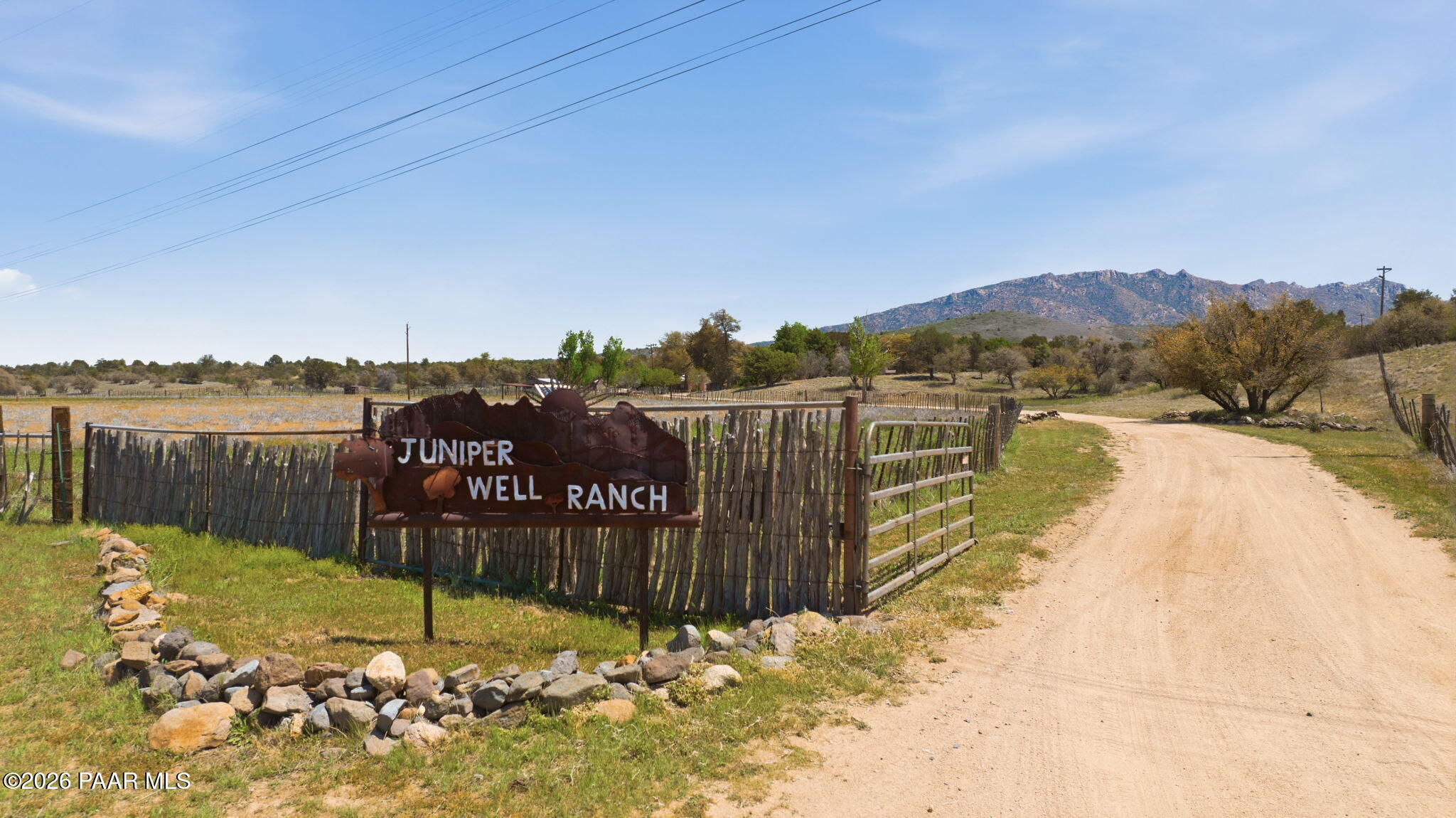 The historic Juniper Well Ranch offers a world of possibilities for creating a four season family compound, wedding/event venue, camp, corporate/artist/spiritual retreat, winery or equestrian facility with 55 private, fenced acres bordering the National Forest at an elevation of 5,000 feet with a rich water supply, glorious Granite Mountain backdrop, charming cabins, rustic lodges, a large clubhouse, dreamy outdoor gathering spaces and wide open views--all just 20 minutes from Prescott's shops, restaurants and festivals on Courthouse Square and two hours from Phoenix and Sky Harbor Airport. ⧫ The original Rock Well House, built around the turn of the 20th century, and an ancient Alligator Bark Juniper Tree welcome you to the property. All the buildings and cabins are perfectly spaced about the perimeter of the 55 acres with the Celebration Area, dispersed camping and teepee decks at the center. ⧫ The Sante Fe Station Clubhouse, an homage to the Santa Fe & Burlington railroad that runs along the EAST side of the property, and is designed for large gatherings with a grand hall with high ceilings, full kitchen, bathrooms and fireplace. ⧫The Celebration Patio and giant entertaining tent with string lights lies at the center of the property where a lily pond and water feature are framed by a lush canopy of shade trees. A wedding altar and fragrant herb and flower garden adds to the natural beauty of the space. The Cantina and Bodega casitas provide refrigerators, freezers, sinks and food prep stations for events. A labyrinth captures the 360 degree mountain beauty while strolling along its path. ⧫ The Cafe has a rustic bar, commercial kitchen, cooler, prep zone, seating area, retail space and restrooms which can be accessed from both indoor or locked off for outdoor access only. ⧫ Manzanita Manor has large decks and open living spaces, kitchen, three bedrooms, 2 1/2 baths and lies close to the center of activity on the property near The Cafe. ⧫ The Granite Rose Cabin has a full kitchen, one bedroom, a loft and one full bath. ⧫ The Purple Sage Cabin has a full kitchen, one bedroom with bunk beds and a full bath. ⧫ The Adobe House was handcrafted on site and features a full kitchen, one bedroom and one full bath. ⧫ Apurva Lodge is a quintessential log cabin with wood burning fireplace and rambling front deck for soaking in the non-stop view of the distant mountains. It has a full kitchen, spacious great room with large windows, a primary suite upstairs, two bedrooms and bath on the main, and a lower level with one bedroom, studio or media room and two garages. Below this cabin is a round pen arena to work horses and 4 stall shelters and fencing. ⧫ The Yurt is a peaceful shelter to stargaze, meditate and camp. Complete with a wood burning stove and kitchen. ⧫ The property also includes multiple barns, tack room, hay loft, tool shed, horse stalls with drains and electric, and RV dumps. ⧫ Juniper Well Ranch lies in Tonto Flats, a sub-irrigated area with abundant ground water which feeds the ancient Juniper trees, as well as Cottonwood, Black Walnut, Pine, Black Jack and Gamble Oak and Manzanita trees. Wildlife such as bobcats, deer, rabbits, javelina, coyotes, squirrels and birds of prey are frequent visitors to the ranch. ⧫ This property offers great income potential in an unparalleled, pastoral ranch setting.  Square footage and acreage are for all buildings (except yurt) and four contiguous parcels. Check out Juniper Well Ranch's social media to see lots more lifestyle photos to get the full sense of this extraordinary place.