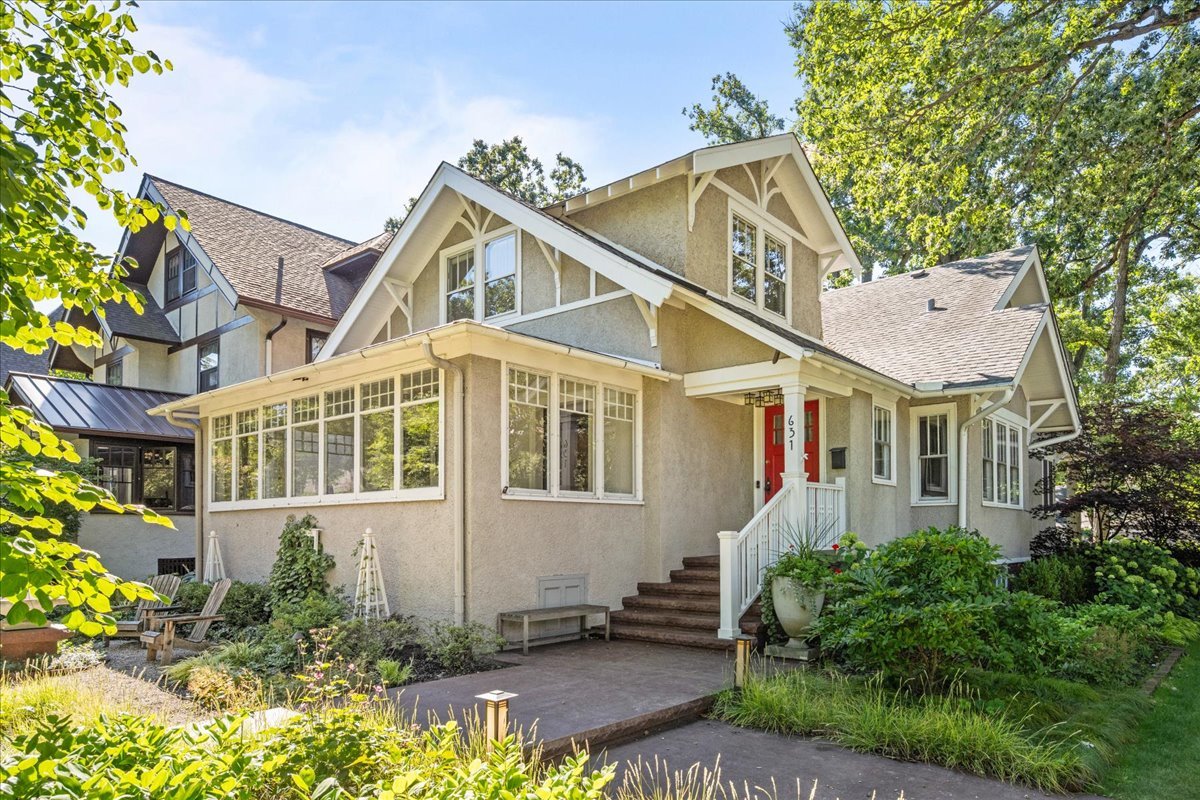 Welcome to 631 Central Avenue, in the heart of East Wilmette and discover exceptional living in this remarkable home that seamlessly blends elegance with comfort. Your journey begins with a captivating front patio and fountain, artfully surrounded by native wildflowers that create a welcoming entrance to this property. Step inside to soaring 9-foot ceilings and gleaming hardwood floors that flow throughout the main level. The year-round sunroom floods the space with natural light, creating a seamless connection to the spacious living room. Here, exposed wood beam ceilings, a gas fireplace, and charming leaded glass windows create an atmosphere of warmth and sophistication. The dining room continues the beamed ceiling theme, establishing visual continuity throughout the entertaining spaces. An expansive family room offers wide views of the picturesque backyard, while a versatile large bedroom, currently configured as a home office, provides flexible living options alongside a convenient full bathroom. The heart of the home features a sun-drenched kitchen surrounded by windows, complete with a generous breakfast bar and custom cabinetry. The adjacent butler's pantry, showcasing glass cabinetry and abundant storage, serves as the perfect hub for entertaining. The primary bedroom suite offers a true sanctuary with beautiful hardwood floors, generous closet space, and flexible room for a home office, sitting area, or nursery. Two additional well-appointed bedrooms and a full bathroom complete this level. The finished basement transforms everyday living with new flooring throughout, featuring a fantastic recreation room with impressive ceiling height, a dedicated theater room complete with authentic movie theater carpet, plus an additional large bedroom and full bathroom. The fully fenced backyard extends an impressive 209 feet, creating a private oasis enhanced by mature landscaping and an automatic sprinkler system. The two-car garage, accessed from the alley, includes a new concrete parking pad that doubles as a sport court, providing additional recreational space and parking flexibility. This spectacular location places you just blocks from top-rated schools, the stunning beaches and parks of Lake Michigan, Wilmette's vibrant village center, and the newly revitalized Plaza del Lago shopping and dining destination. Enjoy move-in ready elegance with fresh paint throughout and numerous updated fixtures that enhance the home's timeless appeal.