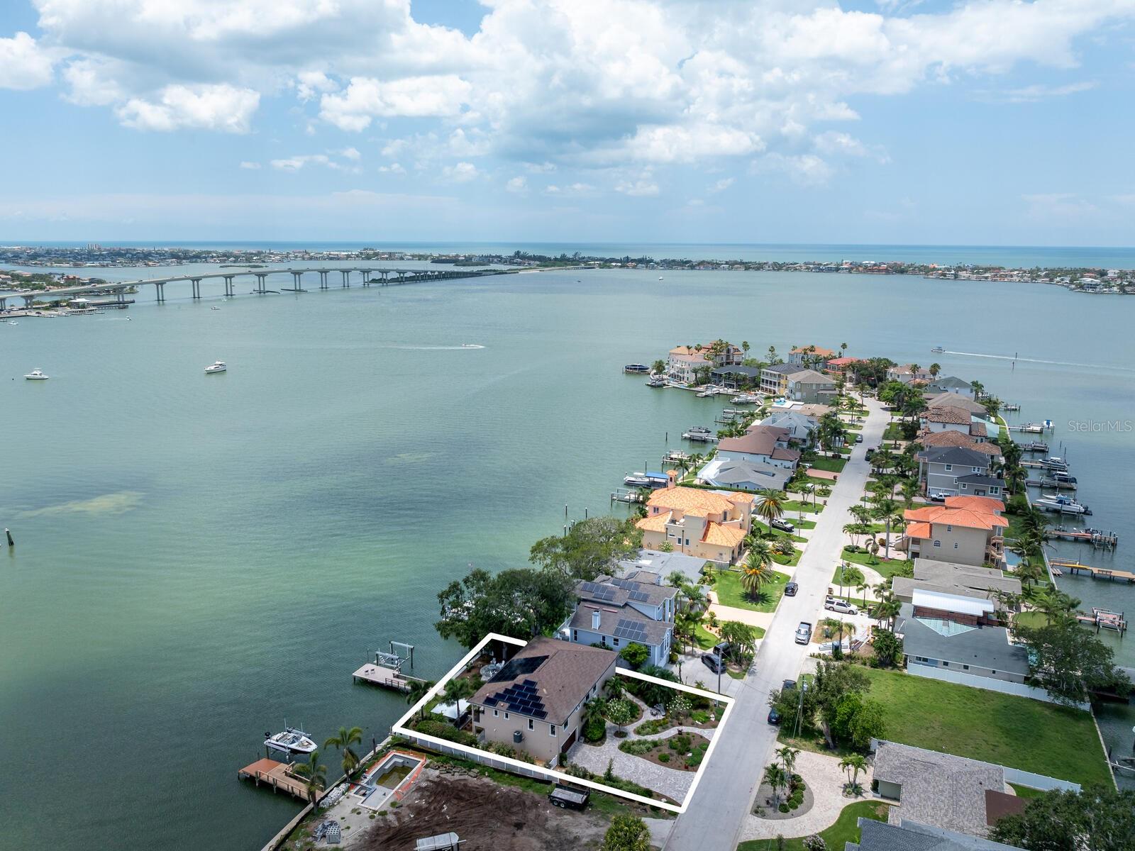 NEW 2019 CUSTOM HOME BUILT TO CURRENT STORM CODES...living level of home had no issues with recent storms...this exquisite custom-built home offers the best of Belleair waterfront living with breathtaking SOUTHERN FACING OPEN WATER VIEWS of the Intracoastal Waterway and the Belleair Causeway. Designed for elevated living and efficiency, this residence blends waterfront luxury with smart upgrades and unmatched views. A RESIDENTIAL ELEVATOR provides easy access to the main level, where sunlight fills the open-concept living space featuring 9-foot ceilings, crown molding, porcelain tile and motorized window treatments throughout. HIGH-IMPACT WINDOWS AND DOORS ensure peace of mind and energy efficiency, while whole-home NAD Blue Sound and KEF audio systems deliver immersive sound indoors and out. THIS HOME IS POWERED BY PAID IN FULL SOLAR PANELS AND HAS 3 POWER WALLS FOR WHOLE HOME BATTERY BACKUP... EASY AND EFFICIENT! The CHEF'S KITCHEN is a SHOWSTOPPER with incredible Blue Bahia granite countertops and backsplash, an oversized center island, custom cabinetry with built-ins and rollouts, and top-of-the-line appliances including a KitchenAid counter-depth refrigerator, Electrolux five-burner cooktop, built-in Frigidaire Professional convection oven and microwave, and a BUILT-IN 120-BOTTLE WINE COOLER. A motorized electric trash chute also adds convenience to this space. The expansive 63-foot Trex balcony deck is ideal for entertaining or relaxing with its built-in Lion five-burner gas grill and motorized Sun Setter awnings. King Size Primary Suite offers sweeping water views, a large custom walk-in closet and a luxurious spa-style bath with soaking tub, oversized walk-in shower, double vanities, and a private commode room with automated Toto Washlet. Second spacious bedroom features a custom closet with abundant storage. Upscale 2nd Bath with en-suite/hall access features a separate soaking tub, walk-in shower, double sink vanity and a private commode room with Toto Washlet, providing comfort and privacy for guests. The 3rd Bedroom can be used as an Office/Study.  Full-size laundry room is conveniently off the main hall with custom granite and cabinetry. Downstairs, you’ll find FLEXIBLE BONUS SPACE with fabulous water views, removable Endura flood wall system and IMPACT sliding doors to the backyard. This space is IDEAL FOR ENTERTAINING, GAME ROOM or GYM. The extra deep 18 X 33 Ft. 2 STALL GARAGE with epoxy floors (2025), ample storage, and can easily accommodate a golf cart or recreational gear. Outside you’ll find new lush 2025 Florida native landscaping and expansive patios.  2019 BUILT SEAWALL AND YOUR 2019 PRIVATE COMPOSITE DOCK WITH WRAPPED PILINGS includes a remote-controlled 13,000 LB boat lift, dock lighting. water, & Tempest Weather Station. Additional upgrades include a commercial water heater (2025), water softener, electronic HVAC filter system, LED lighting and more. Located in the quaint Town of Belleair with its own police department, recreation center, town hall and over 15 greenspace & dog friendly parks.  Close to Gulf beaches, excellent medical facilities, banking, shopping and dining. A GOLFER'S PARADISE with distinguished Belleair Country Club and Pelican Golf Club. TPA 40 minutes & PIE 30 minutes. This is waterfront living at its finest, blending high-end finishes, smart technology and Florida charm, all with incredible open water views...just bring your boat!  Feature Sheet attached.  Floorplan photos 62&63.