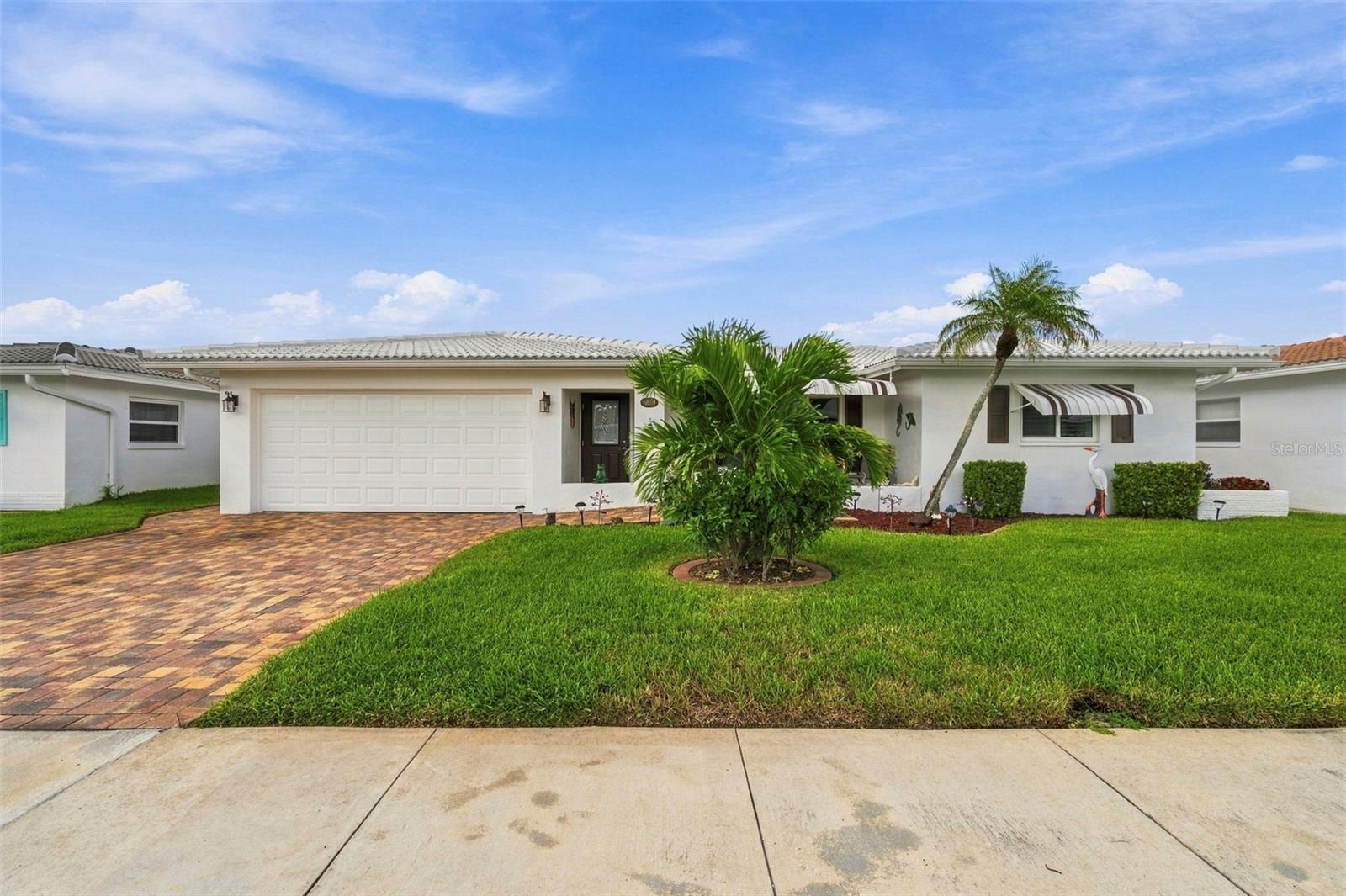 Welcome to the popular Mainlands, a sought-after 55+ golf course community where an active Florida lifestyle meets easy, low-maintenance living! This spacious Eden model, in Unit 4, offers over 1,800 square feet with 3 bedrooms, 2 bathrooms, and a 2-car garage. Enjoy the convenience of golf-cart-friendly living with the golf course (membership required) and community amenities just minutes from your door.Beautifully updated and move-in ready, this home features impact windows installed in 2018, a new tile roof in 2019, and a 2018 central HVAC system. The water heater was replaced in 2025, while the double paver driveway, paver porch, and paver sidewalk were added in 2020, enhancing both curb appeal and functionality. Inside, the spacious renovated kitchen provides plenty of room for cooking and entertaining, both bathrooms have been tastefully updated, and flooring has been updated throughout.The $485 monthly HOA fee provides exceptional value and includes roof replacement and repairs, exterior painting, lawn care, cable, internet, water, sewer, and trash—allowing you to enjoy more of your time and less of your time worrying about maintenance. Plus, no flood insurance is required.The Mainlands offers an inviting 55+ lifestyle with a clubhouse, community pool, golf course, and a welcoming neighborhood atmosphere. Whether you're looking for a full-time residence, winter retreat, or a home where you can enjoy an active, maintenance-friendly lifestyle, this well-maintained and thoughtfully updated home is ready to welcome you!