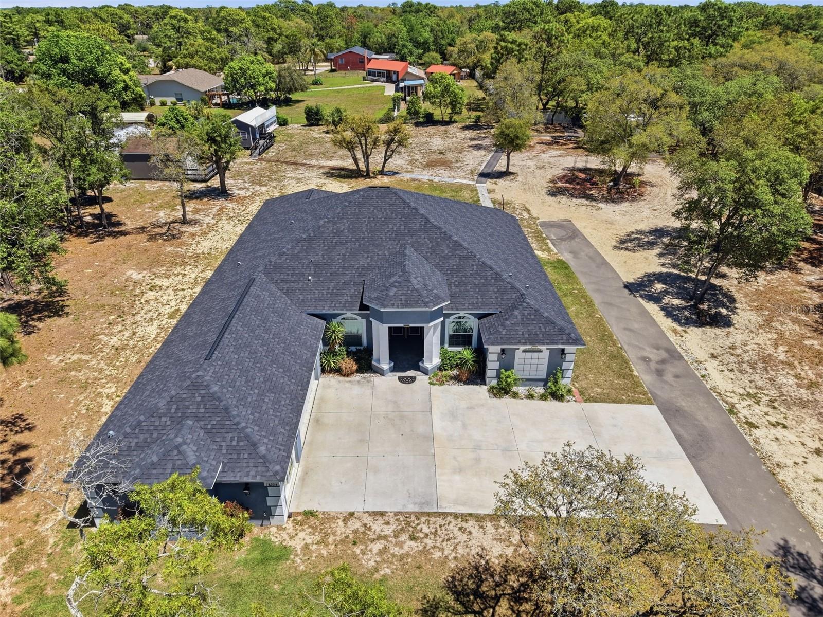 Stunning 2023 custom home by Dream Custom Homes situated on 1.54 acres, offering 4 bedrooms plus a dedicated office, 4 bathrooms, and modern upgrades throughout. This move-in ready home combines the privacy of agricultural zoning with the convenience of being close to shopping, dining, and just 45 minutes to Tampa.Step inside to a spacious open-concept floor plan designed for both everyday living and entertaining. The kitchen features beautiful granite countertops, ample cabinetry, and flows seamlessly into the main living areas. A dedicated office provides the perfect work-from-home space or flex room. Home is fully wired for WIFI. Enjoy Florida living at its best with an extended paver lanai, ideal for relaxing or hosting guests. The property also includes a large 20x16 ft shed, perfect for storage, a workshop, or hobby space. Fully fenced.This home was built with both quality and future planning in mind, featuring underground electrical service (no overhead wires), a 200-amp electrical panel prewired for a future pool, and newer construction for energy efficiency and peace of mind.A rare find, the entire home is fully wheelchair accessible, offering comfort and functionality for a wide range of buyers.If you're searching for a newer construction home on acreage, a custom home with land, or a 4 bedroom home with office near Tampa--this property checks all the boxes. Schedule your private showing today.