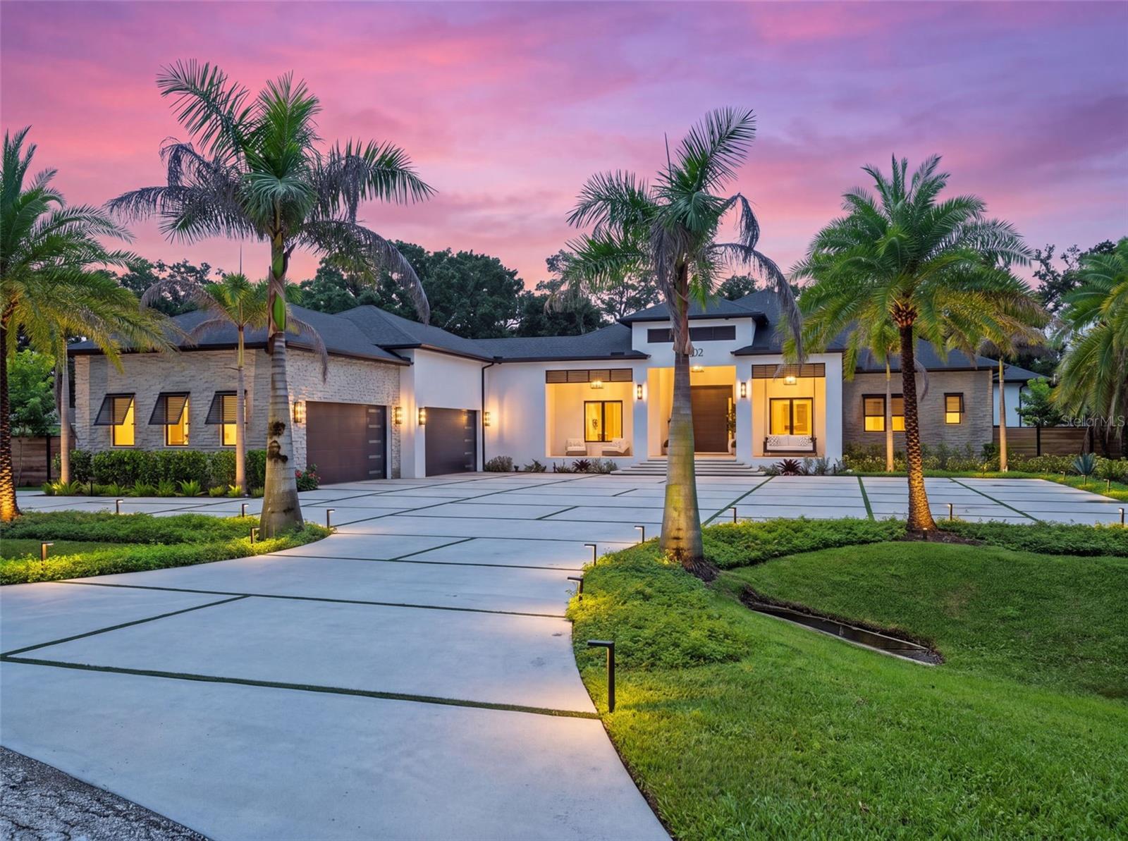 Welcome to Grande Estates, one of Tampa Bay’s newest and most exclusive communities, an intimate gated enclave of just seven custom homes where privacy, space and exceptional craftsmanship define the experience. Grande Estates offers a rare sense of seclusion while remaining remarkably connected to the city. Just 8 minutes from I-275 and within 30 minutes of Downtown Tampa, enjoy the tranquility of estate living with easy access to Tampa’s acclaimed dining, entertainment and vibrant city lifestyle. This exceptional home takes estate living one step further, occupying not one, but two lots, creating 1.87 acres of private, expansive grounds rarely found this close to the heart of Tampa. Sophisticated yet inviting, the home was designed for elevated everyday living and effortless entertaining. A grand custom front door sets the tone, opening to soaring archways, hand stained white oak accents, and warm statement lighting throughout. At the heart of the home is a beautifully appointed chef’s kitchen featuring Wolf and Sub Zero appliances, an eight burner range, custom Wolf hood, built in coffee system, pot filler, dual dishwashers, extensive custom cabinetry and an oversized waterfall island. Just beyond, a dedicated bar with leathered quartz countertops, custom built ins, True ice maker and Wolf wine cooler creates a natural gathering place for entertaining. The primary suite is a private retreat with a spa inspired bathroom centered around an oversized glass enclosed wet room combining a walk in shower and freestanding soaking tub. Herringbone tile, marble look walls and a rainfall showerhead create the feel of a luxury resort. The adjoining vanity and dressing area features floor to ceiling custom cabinetry, a dedicated makeup station, illuminated mirror and statement lighting. Custom dressing spaces provide extensive built in cabinetry, dedicated shoe and handbag storage, display cabinetry and a large center island. Additional bedrooms continue the custom aesthetic with walk in closets and beautifully finished en suite bathrooms. Outside, the home transforms into a private resort. An expansive covered outdoor living area with a warm wood plank ceiling provides multiple spaces for lounging and dining alongside a fully equipped outdoor kitchen with a Green Egg, griddle and oversized burner. Beyond it, an approximately 40x20 foot heated saltwater pool and 6x9 foot spa are surrounded by generous deck space and a panoramic screen enclosure.The attention to detail extends well beyond what meets the eye including 12 Sonos zones, smart privacy glass, blackout window features, semi commercial water filtration with reverse osmosis, and foam insulated CMU block construction.Toward the rear of the home, a dedicated fitness room with its own full bathroom could easily function as an in law suite, guest retreat or private living quarters. Beyond the privacy of Grande Estates, Tampa Bay’s most desirable amenities remain remarkably close. Enjoy convenient access to the University of South Florida, private aviation terminals, premier golf communities including Tampa Palms, Hunter’s Green and Avila, while Raymond James Stadium, Water Street, Downtown Tampa and Tampa International Airport are all less than 30 minutes away. Private when you want it, connected when you need it, and exceptional in every way. Welcome Home!