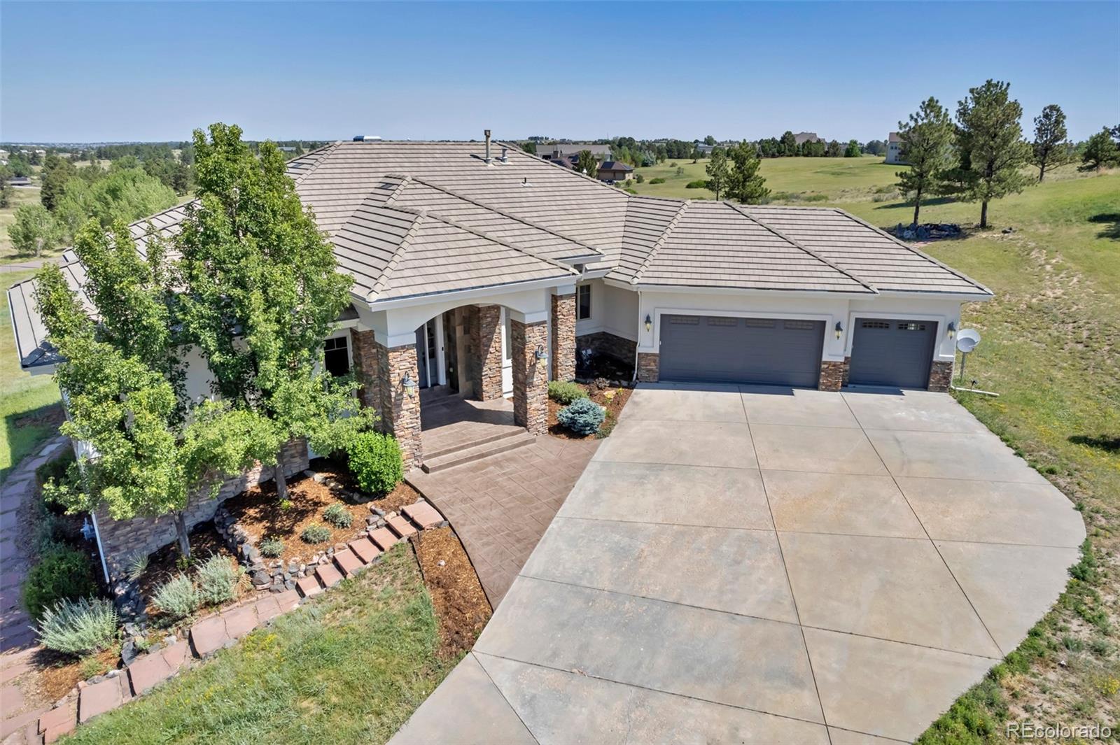 Luxury, privacy, and timeless elegance come together in this exceptional custom estate on 2.77 beautifully landscaped acres just minutes from downtown Parker. Extensively refreshed and meticulously maintained, this stunning ranch-style home offers an ideal blend of sophisticated design, comfortable everyday living, and breathtaking outdoor spaces.From the moment you arrive, you'll appreciate the home's impressive curb appeal, mature landscaping, and peaceful setting. Inside, expansive windows fill the home with natural light while showcasing picturesque views of the surrounding property. Thoughtfully designed for both entertaining and everyday living, the open floor plan features spacious gathering areas, soaring ceilings, and quality craftsmanship throughout.The well appointed gourmet kitchen serves as the heart of the home, flowing seamlessly into the dining and living areas, making it perfect for hosting family and friends. The luxurious primary suite provides a private retreat with a spa-inspired bath and generous walk-in closets, while additional bedrooms offer comfort and flexibility for family, guests, or home office space.The finished lower level expands the living space with a well appointed kitchen, theater room, along with room for recreation, entertaining, fitness, or multi-generational living.Step outside to experience Colorado living at its finest. The nearly three-acre property provides exceptional privacy with a sport court which is perfect for pickle ball, tennis, basketball or tennis, expansive outdoor living areas, and endless possibilities for entertaining, gardening, recreation, or simply enjoying the peaceful surroundings.Located in one of Parker's most sought-after acreage communities with NO HOA, this remarkable property offers the rare combination of estate living with convenient access to shopping, dining, exceptional schools and all that Parker has to offer.This is Colorado luxury living at its finest.