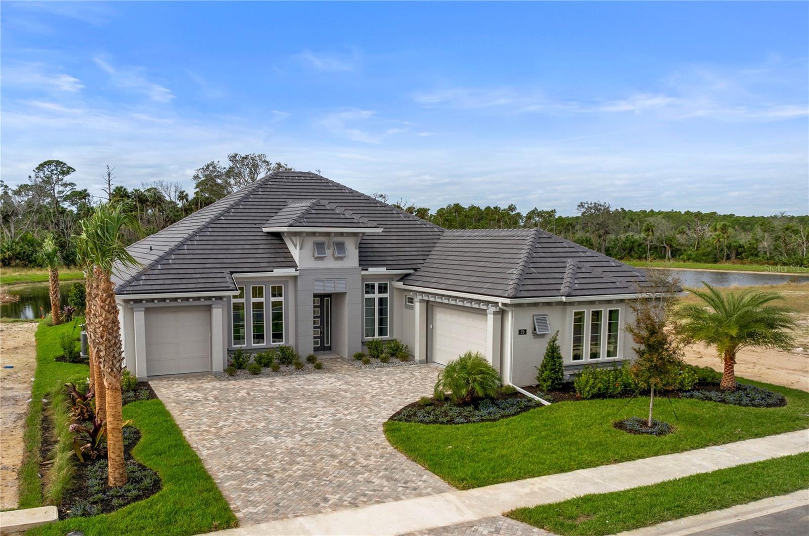 Discover the epitome of elegance in this brand-new Riverside ESTATE located in the prestigious Veranda Bay Community of Flagler Beach. This custom-built ICI Homes masterpiece, the Egret VII, offers 4 bedrooms, an office, 4 full baths, and a 3-car garage, all set on a spacious LAKESIDE lot. As you step through the glass front door, you're welcomed by high ceilings and an open layout. The family room features white PORCELAIN TILE floors, gorgeous COFFERED ceiling, and sliding doors that open to the lanai, seamlessly connecting to the grand kitchen. The kitchen is a chef's dream, boasting QUARTZ countertops, a large island, 42-inch soft-close WOOD CABINETS, a tile backsplash, stainless steel appliances, and a pantry. Enjoy meals in the breakfast nook with large windows and a stunning chandelier, or in the formal dining room adorned with porcelain tile floors and a crystal chandelier located at the front of the home. The private master suite offers TRAY ceiling, DUAL WALK-IN CLOSETS, large windows with serene lake views, and a luxurious master bathroom with quartz countertops, a long vanity with dual sinks, and a tiled walk-in shower. The split floor plan ensures privacy, with three additional bedrooms each featuring en-suite baths. Bedrooms 2 and 3 include walk-in closets with a Jack and Jill bathroom between them, while Bedroom 3 also offers lanai access. Bedroom 4 is a private suite in its own wing. An office/den with a tray ceiling and double doors overlooks the family room, and the extended laundry room provides ample space and cabinetry. Outside, the oversized lanai features a brand-new OUTDOOR KITCHEN with a grill, fridge, sink, and cabinets, all overlooking the tranquil lake. Enjoy privacy with no neighbors to the south, and benefit from a 3-car garage, PAVER driveway, TILE ROOF, irrigation system, impact windows and sliders, exquisite light fixtures throughout, and views of the Intracoastal Waterway out your front windows. This home is located in the Riverside community of Veranda Bay, offering future amenities such as a gated entry, clubhouse, resort-style pool, fitness center, community marina, tennis and pickleball courts, and a dog park. Just one mile from beautiful Flagler Beach, this is a fantastic opportunity to own a brand-new estate home with everything you desire in a prime location.