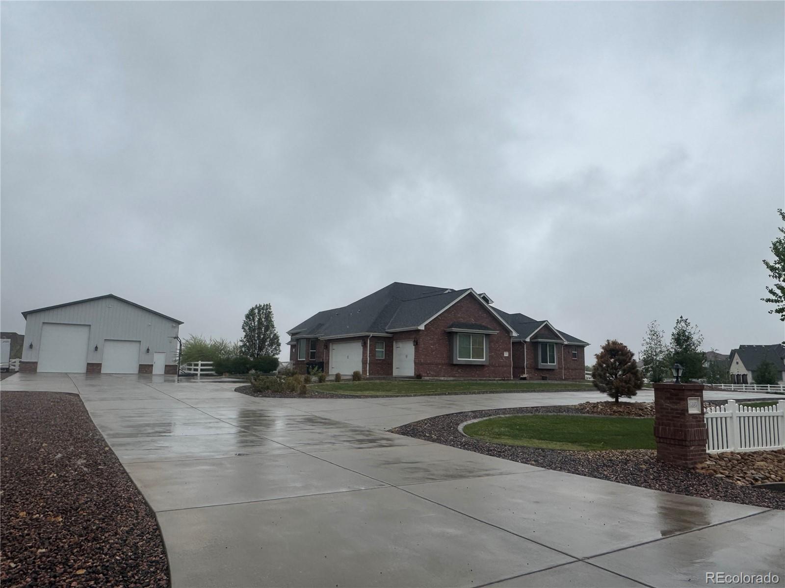Welcome home to this approximately 2.25-acre property in unincorporated Adams County. This beautifully maintained craftsman-inspired home blends comfort, character, and functional acreage living. Surrounded by mature landscaping, native grass, and open outdoor space, the property offers a peaceful setting approximately 10 minutes from Prairie Center-Brighton and 20 minutes from Denver International Airport.Enjoy evenings around the outdoor fire pit, ideal for gatherings, BBQs, Colorado sunsets, and s’mores. Features include dual concrete driveways, ample parking, three 220-volt hookups in the shop, an additional 220-volt hookup in the attached garage, and covered front and back patios for year-round outdoor living.Inside, rich stained hickory hardwood flooring and craftsman-inspired finishes carry throughout the home. The kitchen is designed for everyday living and entertaining with a gas cooktop and optional electric hookup, exterior-vented hood, double convection ovens, farmhouse apron sink, and connected walk-in pantry with dedicated electrical accommodations for an additional refrigerator and freezer. New carpet adds a fresh feel throughout select areas. The unfinished basement offers future expansion potential with 2 bathroom rough-ins, egress windows for additional bedrooms/hobby-rooms, entertaining space, fitness area, storage, and/or multigenerational living.The fully insulated outbuilding with acoustic perforated interior paneling is ideal for your workshop, hobbies, vehicles, and equipment storage. A spacious approx. 9’ x 45’ mezzanine provides additional flexibility. Two overhead garage doors — approx. 14’ & 10’  tall — with automatic openers welcome RVs, lifted vehicles, trailers, and a variety of storage needs. The property provides convenient access to Brighton, DEN, and nearby transit while maintaining the privacy and feel of country living.