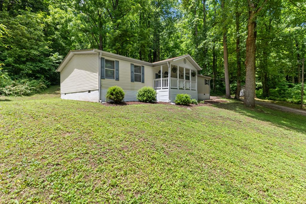 Discover the beauty of Kibler Valley in Ararat, VA, with this charming 3-bedroom, 2-bath home situated on 1.69 acres. Surrounded by nature and within walking distance of the Dan River (550 ft.), this property offers the perfect blend of country living and outdoor recreation. The open floor plan features a living room, dining area, kitchen, and a cozy den highlighted by a beautiful stone wood-burning fireplace. Numerous recent updates include fresh interior paint, updated kitchen cabinets and countertops, remodeled bathrooms with new showers, vanities, new exterior doors, and updated laminate flooring throughout much of the home. Also, the heat pump and roof were replaced approximately 4-year-old ago. Step outside and enjoy the sights and sounds of nature from the covered front porch or relax on the back deck, perfect for grilling, entertaining, or simply unwinding after a day outdoors. Gentle streams run on the property, creating a peaceful setting with walnut trees, mountain laurel, and different seasonal wildflowers. Outdoor enthusiasts will love the property's location being steps from the Dan River, known for trout fishing, kayaking, tubing, canoeing, and scenic river adventures. Whether you're searching for a full-time residence, weekend getaway, vacation home, or investment opportunity, this property offers an exceptional lifestyle surrounded by the natural beauty of the Blue Ridge Mountains. Experience the privacy and charm this property has to offer and make this special property your own.